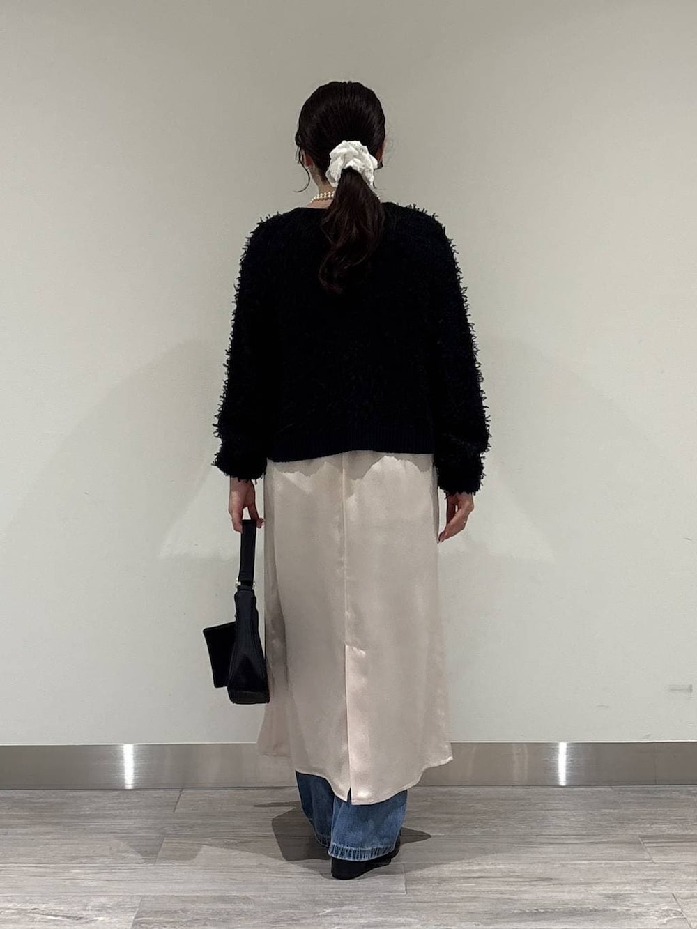 ブラック系のローファー、ブラック系のハンドバッグ、ブラック系のカーディガン/ボレロを着用したレディースの冬コーディネートの3枚目の写真