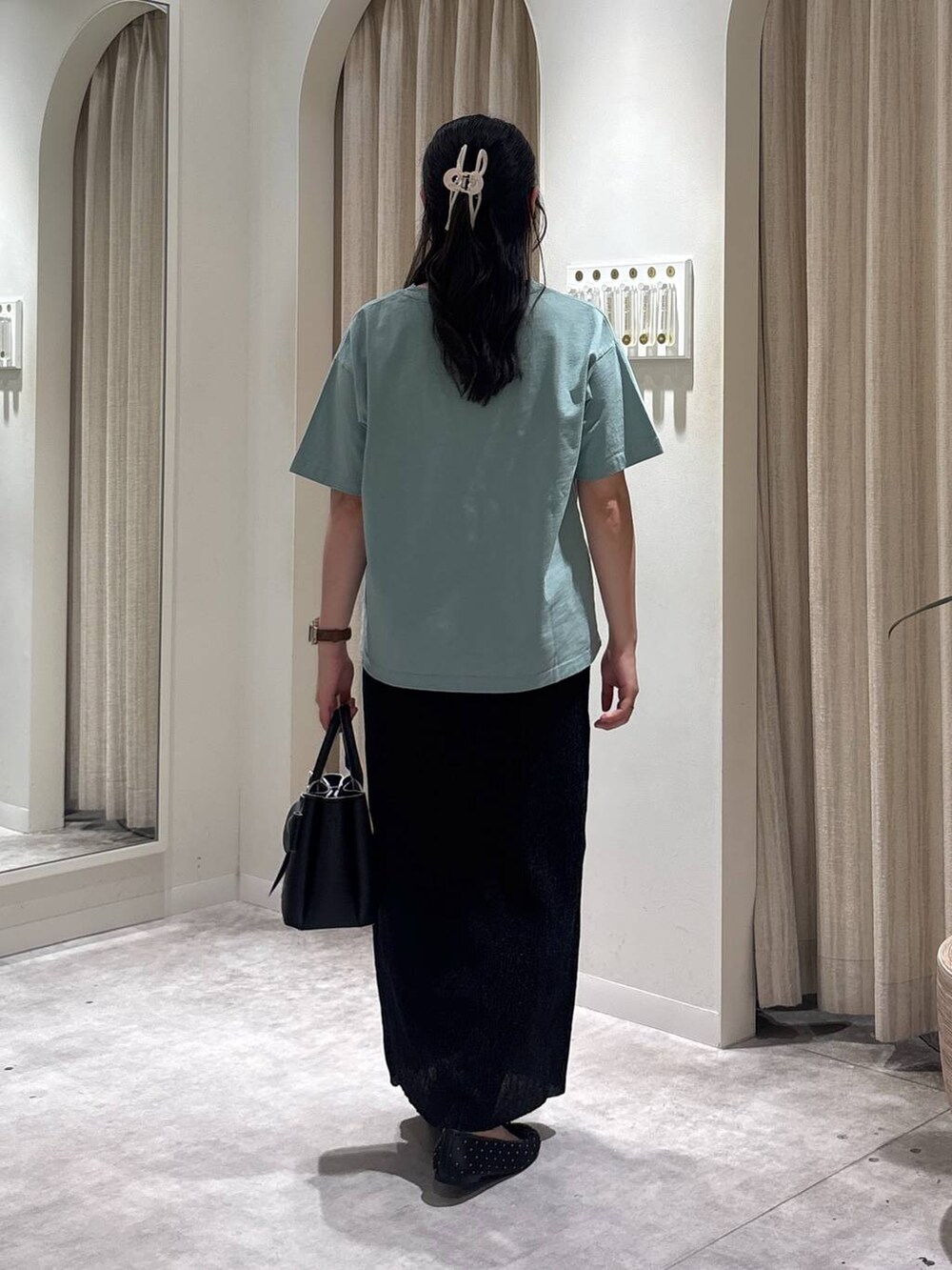 ブラック系のショルダーバッグ、ブラック系のバレエシューズ、ブラック系のスカートを着用したレディースの春コーディネートの3枚目の写真