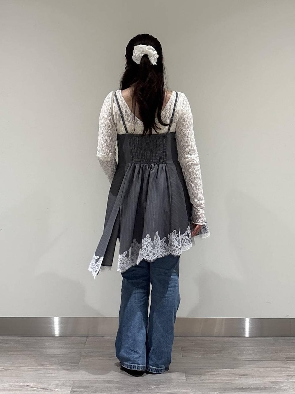 ブルー系のデニムパンツ、ブラック系のパンプス、ホワイト系のTシャツ/カットソーを着用したレディースの冬コーディネートの3枚目の写真