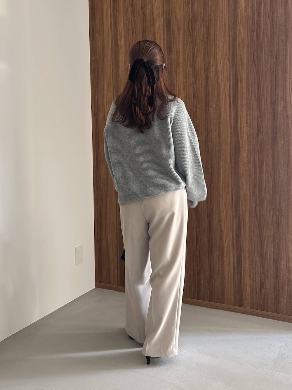 ブラック系のパンプス、ブルー系のニット/セーター、ブラック系のハンドバッグを着用したレディースの冬コーディネートの3枚目の写真