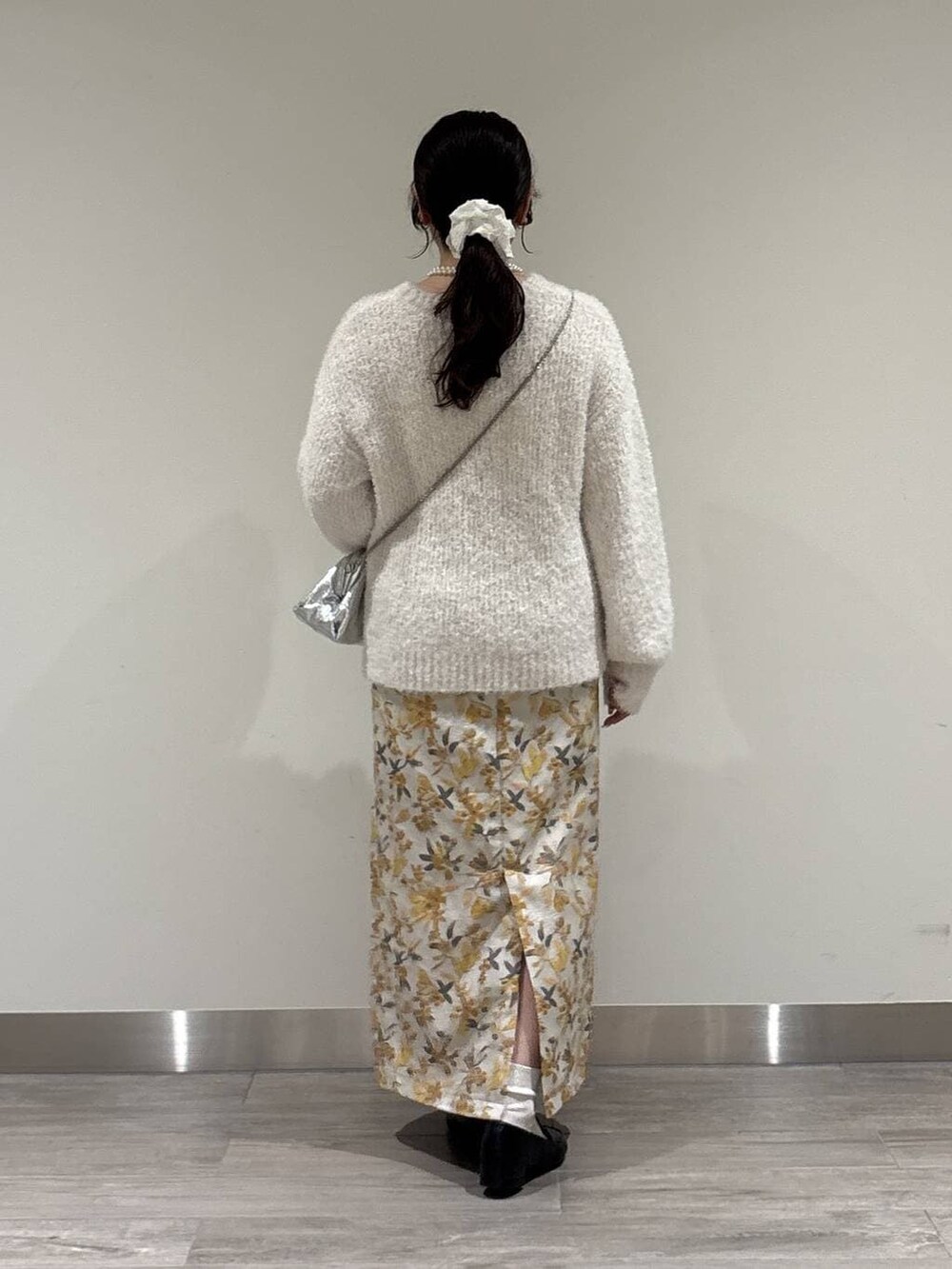 ブラック系のローファー、ホワイト系のニット/セーター、シルバー系のショルダーバッグを着用したレディースの冬コーディネートの3枚目の写真