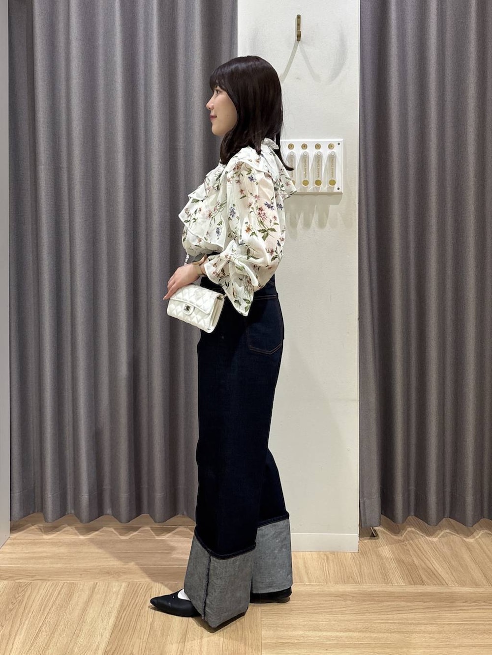 ブラック系のパンプス、ホワイト系のシャツ/ブラウス、ブルー系のデニムパンツを着用したレディースの春コーディネートの2枚目の写真