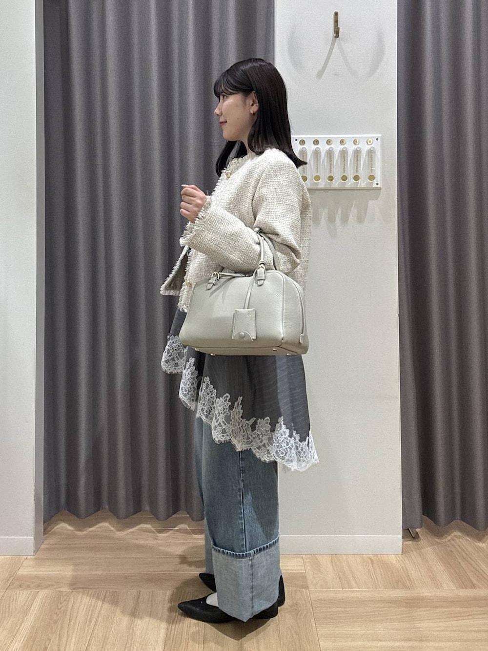 ベージュ系のハンドバッグ、ブラック系のパンプス、ホワイト系のTシャツ/カットソーを着用したレディースの春コーディネートの2枚目の写真