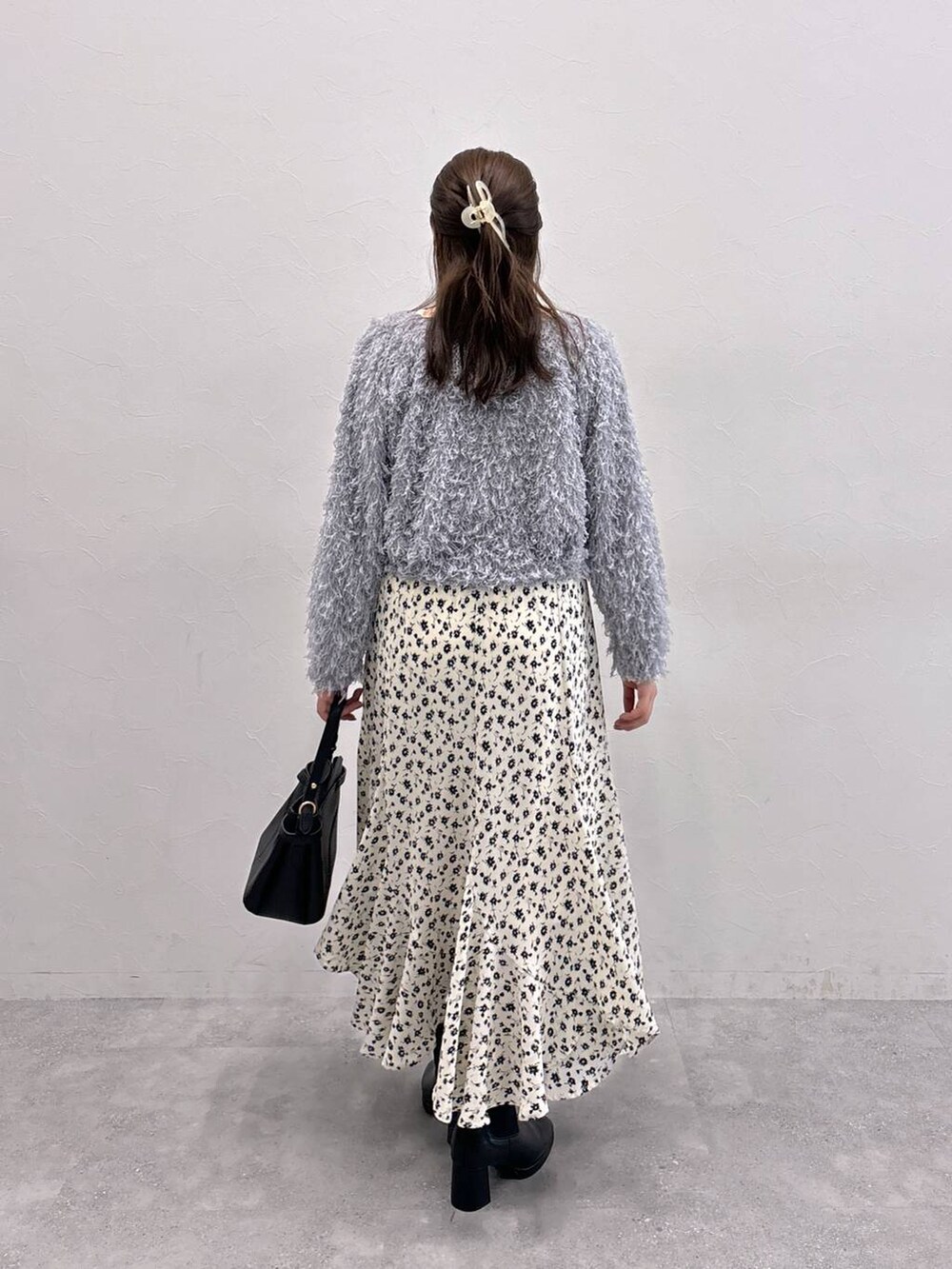 ブラック系のショルダーバッグ、ホワイト系のスカート、ホワイト系のTシャツ/カットソーを着用したレディースの秋コーディネートの3枚目の写真