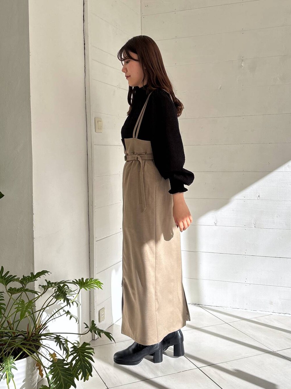 ブラック系のブーツ、ブラウン系のスカート、ブラック系のシャツ/ブラウスを着用したレディースの冬コーディネートの2枚目の写真