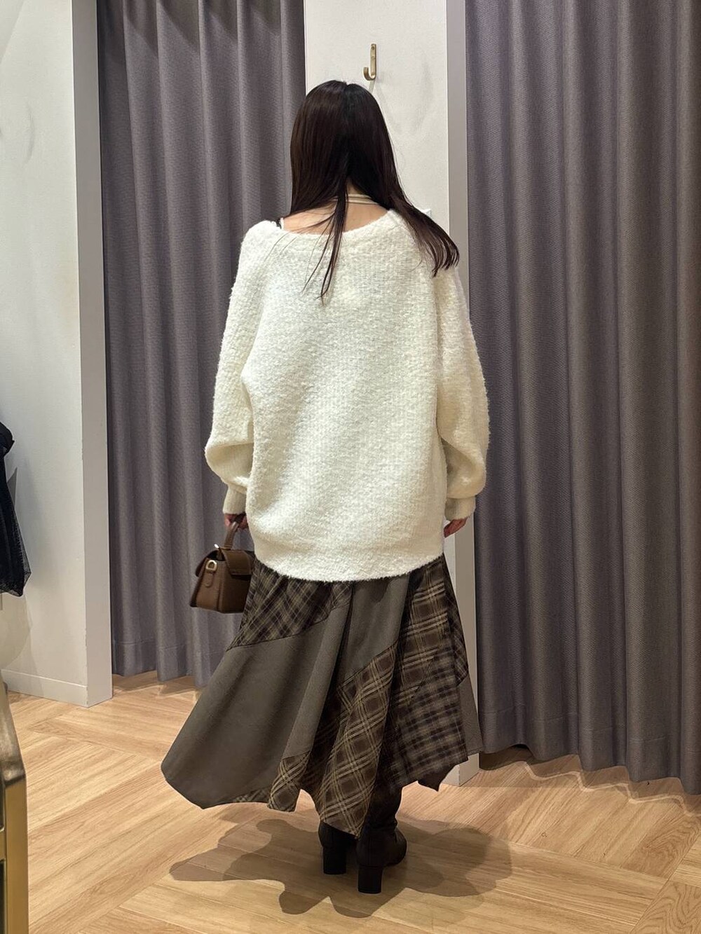 ホワイト系のカーディガン/ボレロ、ブラウン系のワンピース、ホワイト系のキャミソールを着用したレディースの秋コーディネートの3枚目の写真