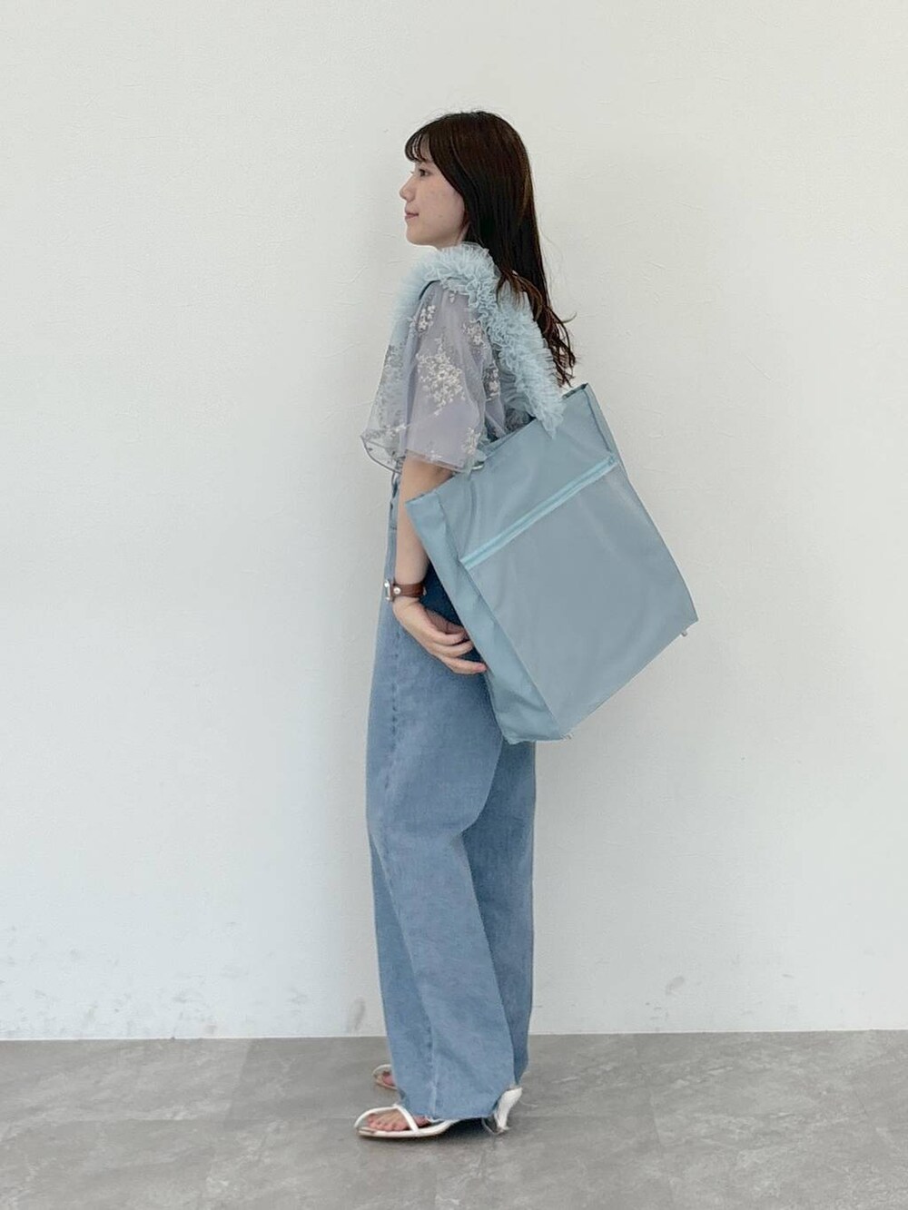 ブルー系のシャツ/ブラウス、ホワイト系のサンダル、ブルー系のデニムパンツを着用したレディースの夏コーディネートの2枚目の写真