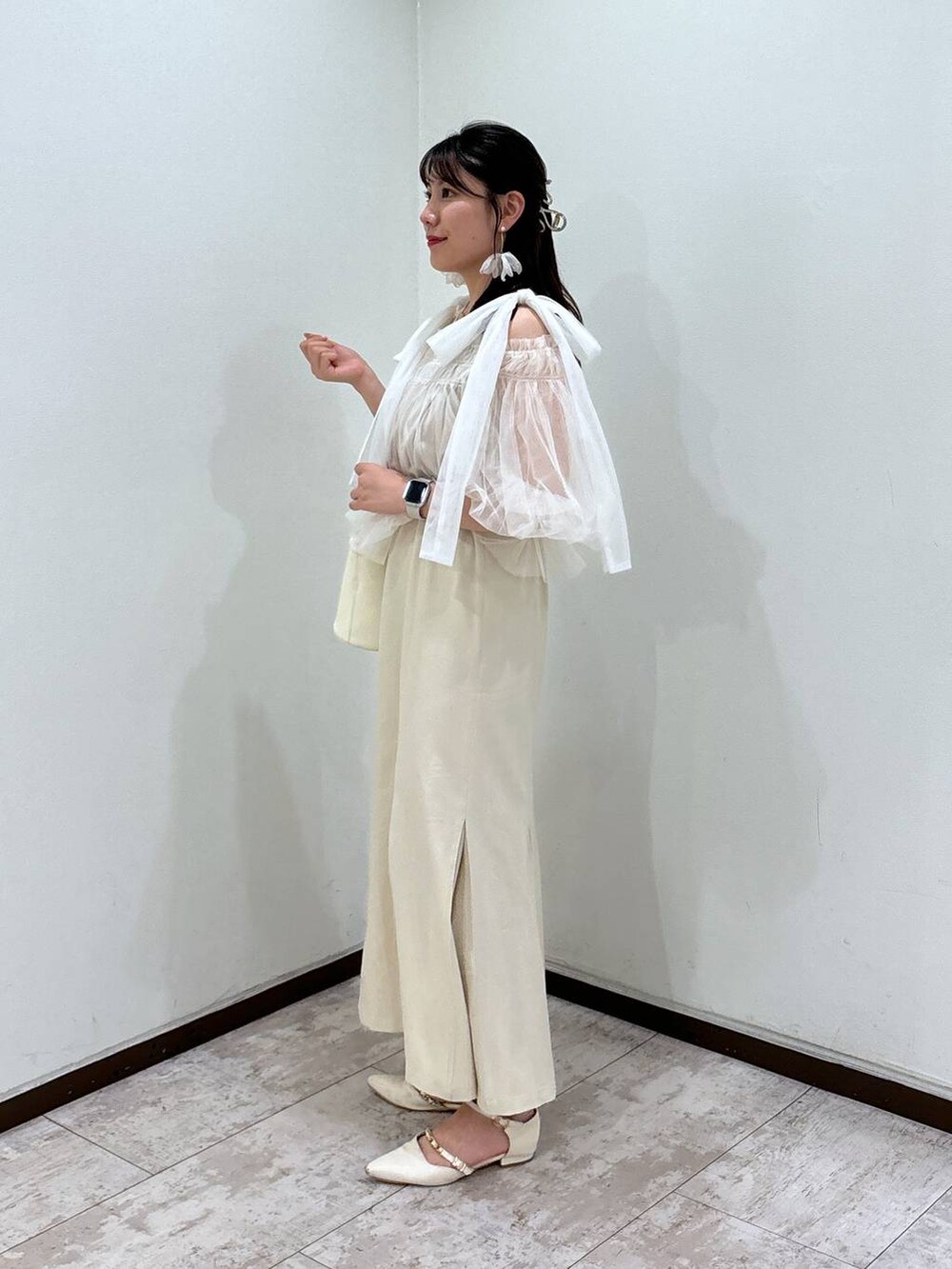 ホワイト系のハンドバッグ、ホワイト系のパンプス、ホワイト系のシャツ/ブラウスを着用したレディースの夏コーディネートの2枚目の写真