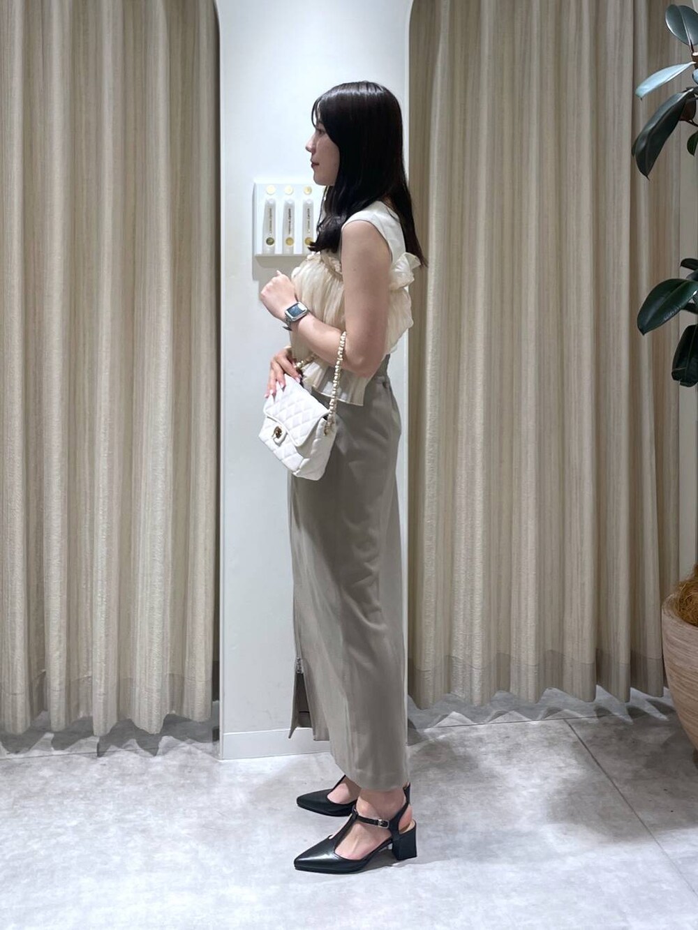 ベージュ系のスカート、ホワイト系のTシャツ/カットソー、ホワイト系のショルダーバッグを着用したレディースの春コーディネートの2枚目の写真