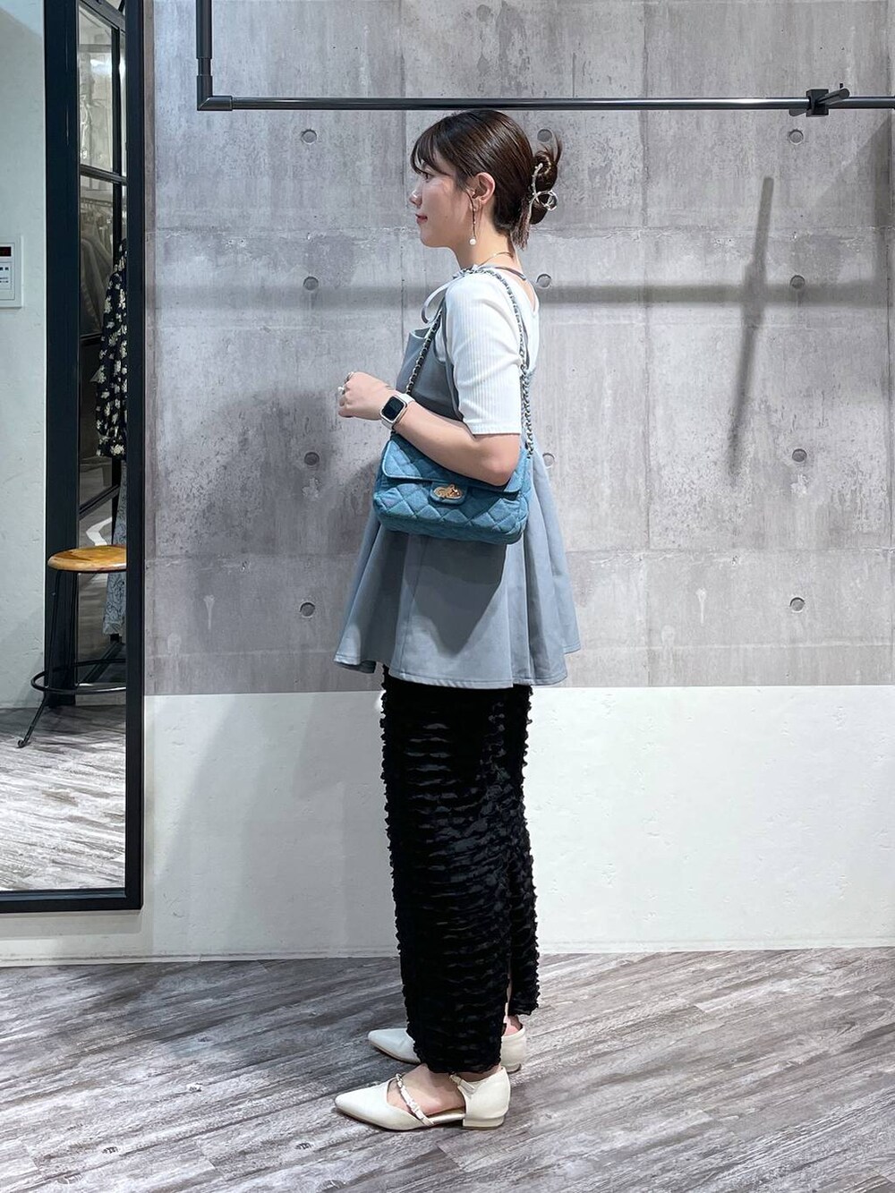 ブルー系のキャミソール、ブラック系のスカート、ブルー系のショルダーバッグを着用したレディースの春コーディネートの2枚目の写真