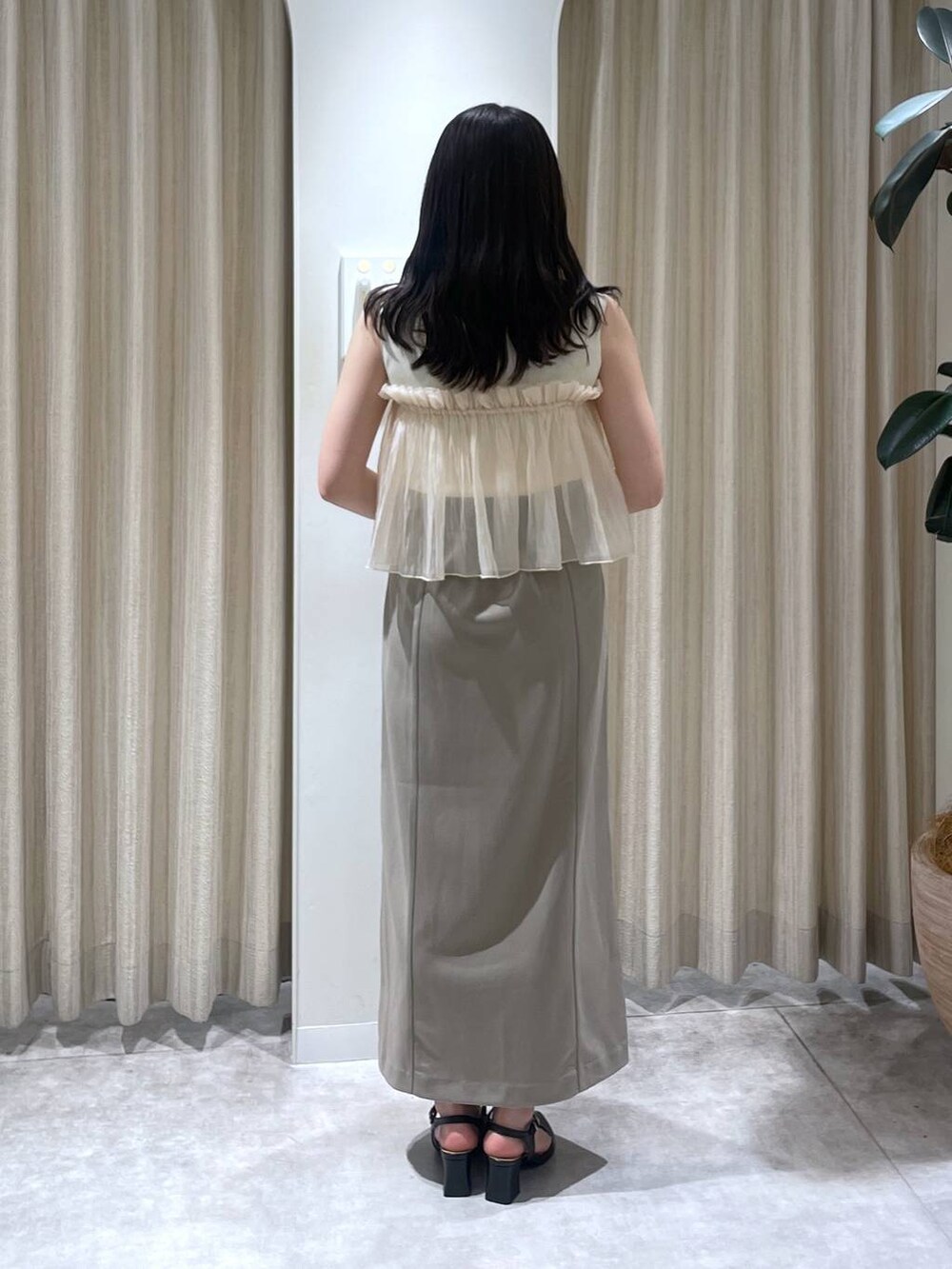 ベージュ系のスカート、ホワイト系のTシャツ/カットソー、ホワイト系のショルダーバッグを着用したレディースの春コーディネートの3枚目の写真