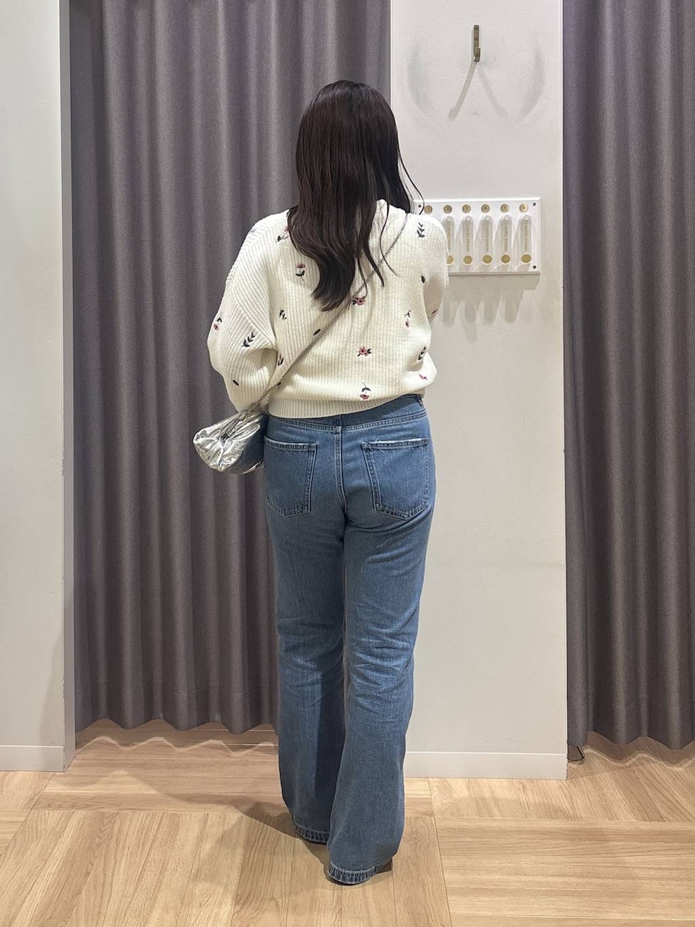 ブルー系のデニムパンツ、シルバー系のショルダーバッグ、ブラック系のパンプスを着用したレディースの冬コーディネートの3枚目の写真