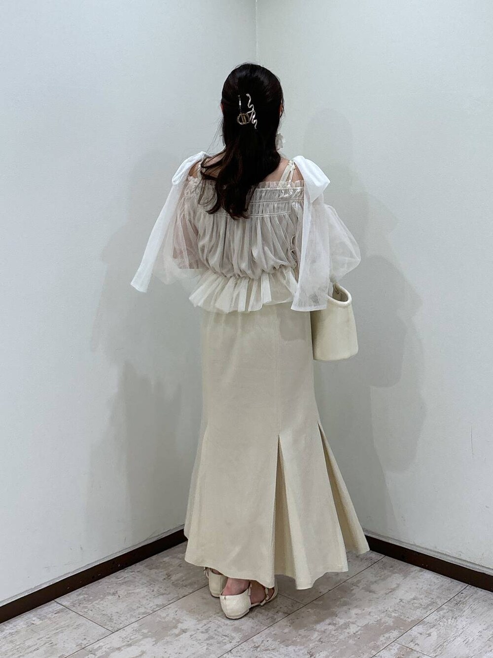 ホワイト系のハンドバッグ、ホワイト系のパンプス、ホワイト系のシャツ/ブラウスを着用したレディースの夏コーディネートの3枚目の写真