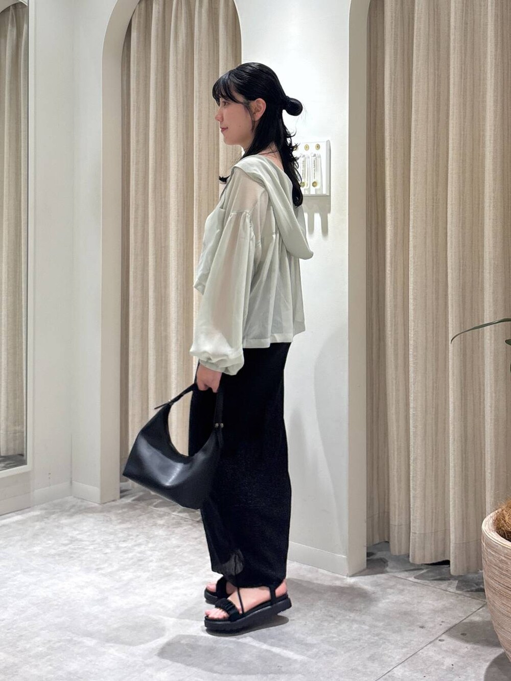 ブラック系のサンダル、グリーン系のパーカー、ホワイト系のキャミソールを着用したレディースの春コーディネートの2枚目の写真