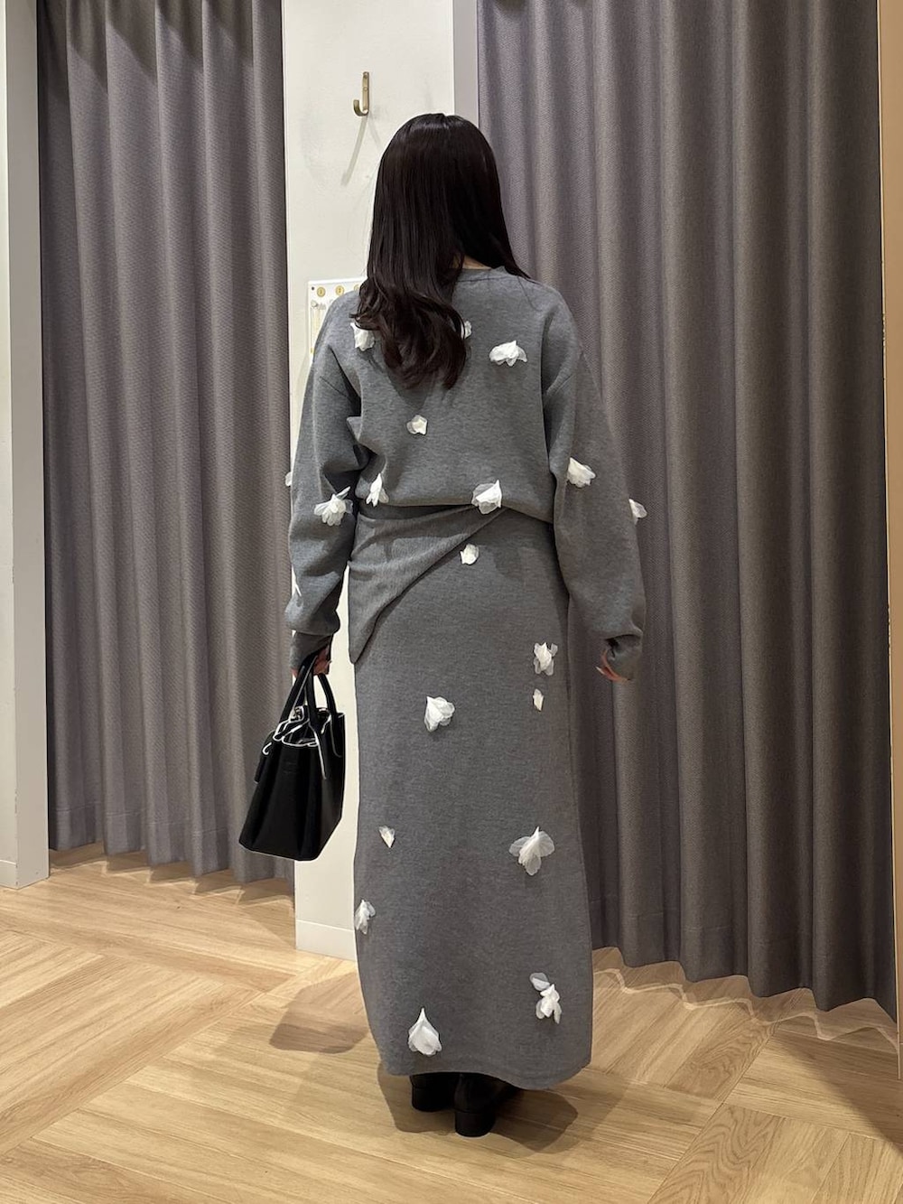 ブラック系のショルダーバッグ、ブラック系のローファー、グレー系のニット/セーターを着用したレディースの冬コーディネートの3枚目の写真