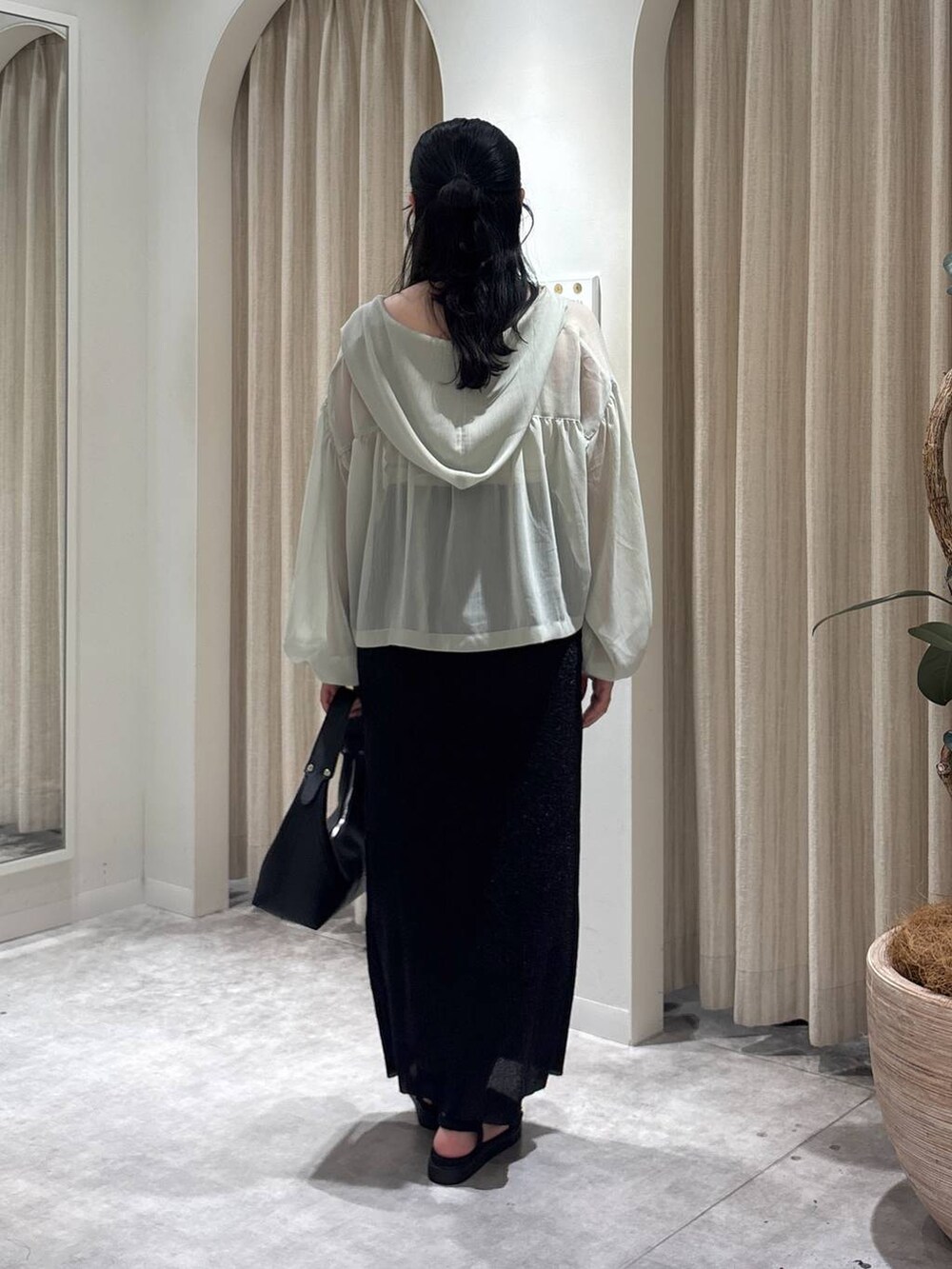 ブラック系のサンダル、グリーン系のパーカー、ホワイト系のキャミソールを着用したレディースの春コーディネートの3枚目の写真