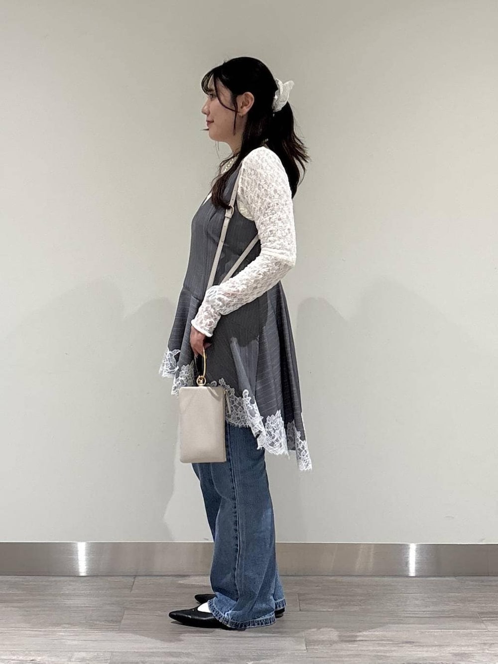 ブルー系のデニムパンツ、ブラック系のパンプス、ホワイト系のTシャツ/カットソーを着用したレディースの冬コーディネートの2枚目の写真