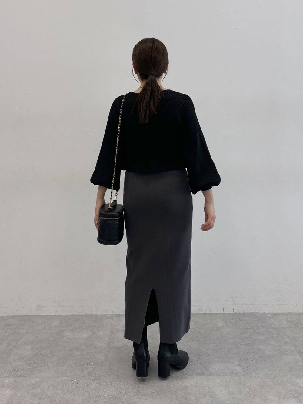 ブラック系のブーツ、ブラック系のショルダーバッグ、ブラック系のカーディガン/ボレロを着用したレディースの秋コーディネートの3枚目の写真