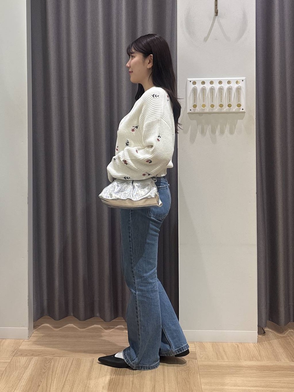 ブルー系のデニムパンツ、シルバー系のショルダーバッグ、ブラック系のパンプスを着用したレディースの冬コーディネートの2枚目の写真