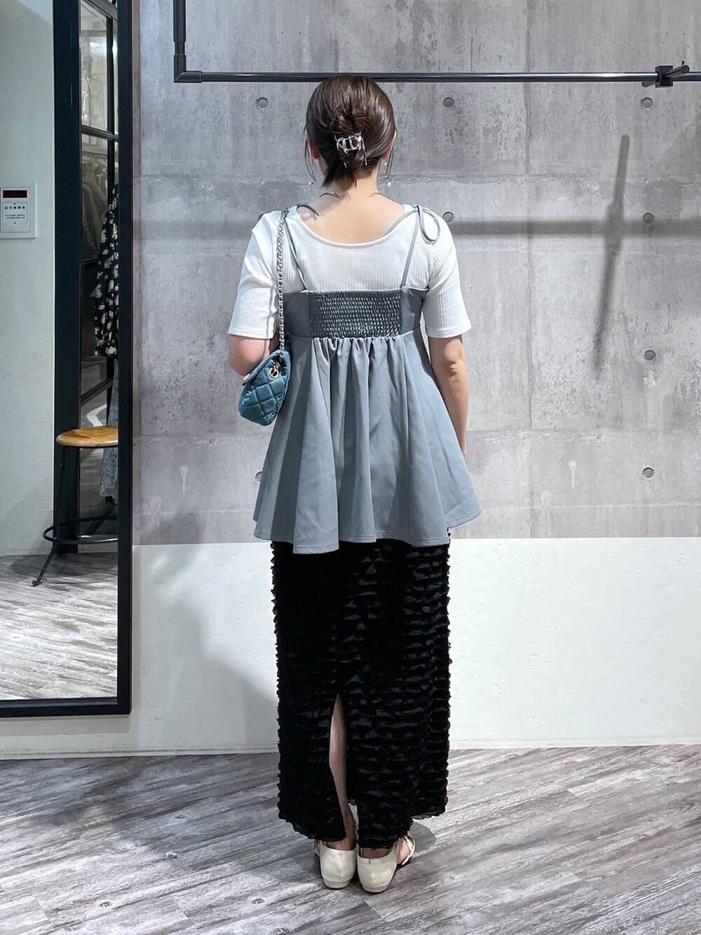 ブルー系のキャミソール、ブラック系のスカート、ブルー系のショルダーバッグを着用したレディースの春コーディネートの3枚目の写真