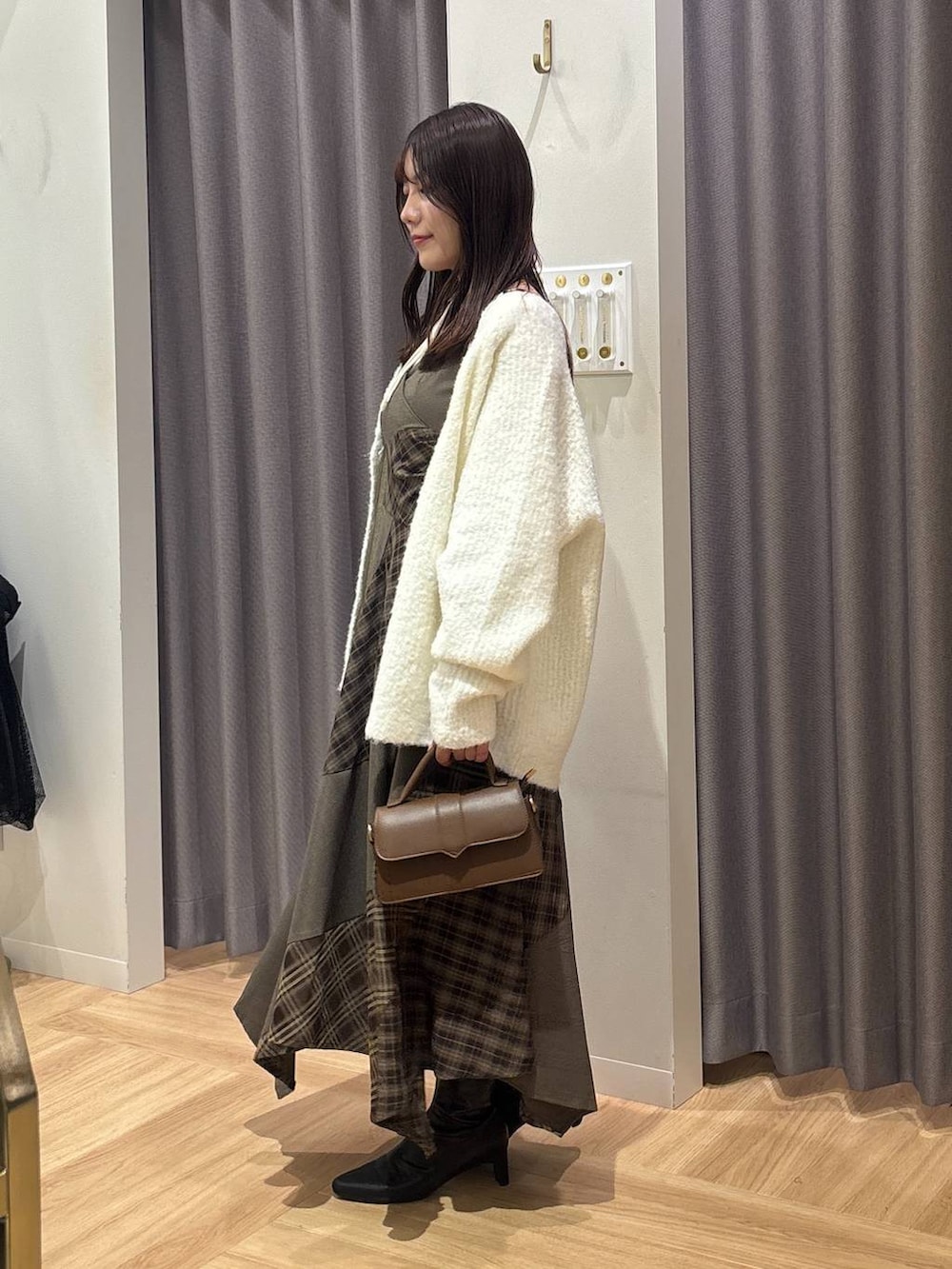 ホワイト系のカーディガン/ボレロ、ブラウン系のワンピース、ホワイト系のキャミソールを着用したレディースの秋コーディネートの2枚目の写真