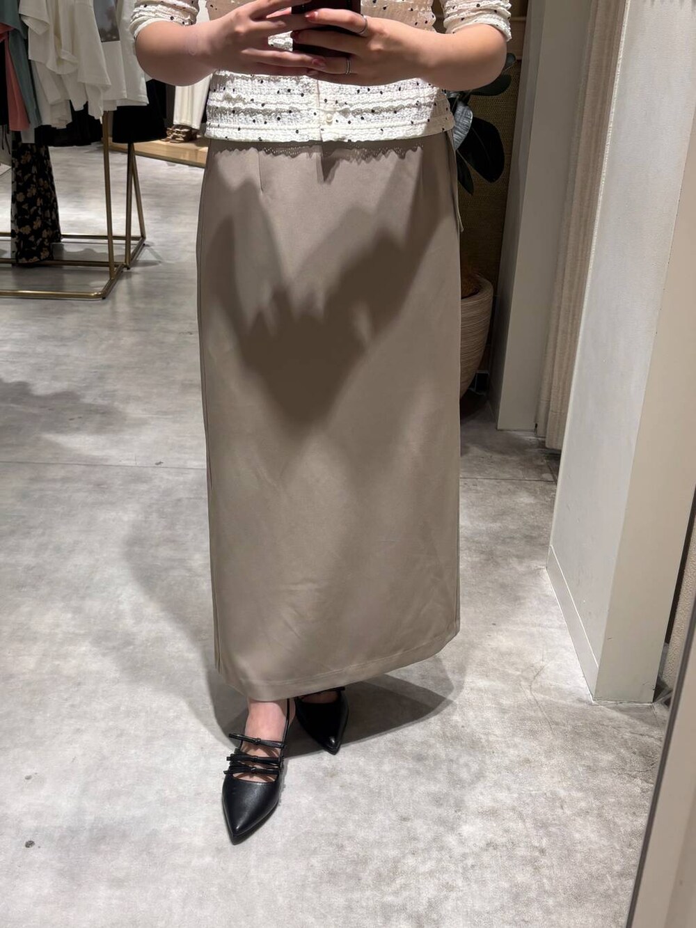 ブラック系のパンプス、ホワイト系のカーディガン/ボレロ、ベージュ系のスカートを着用したレディースの夏コーディネートの3枚目の写真