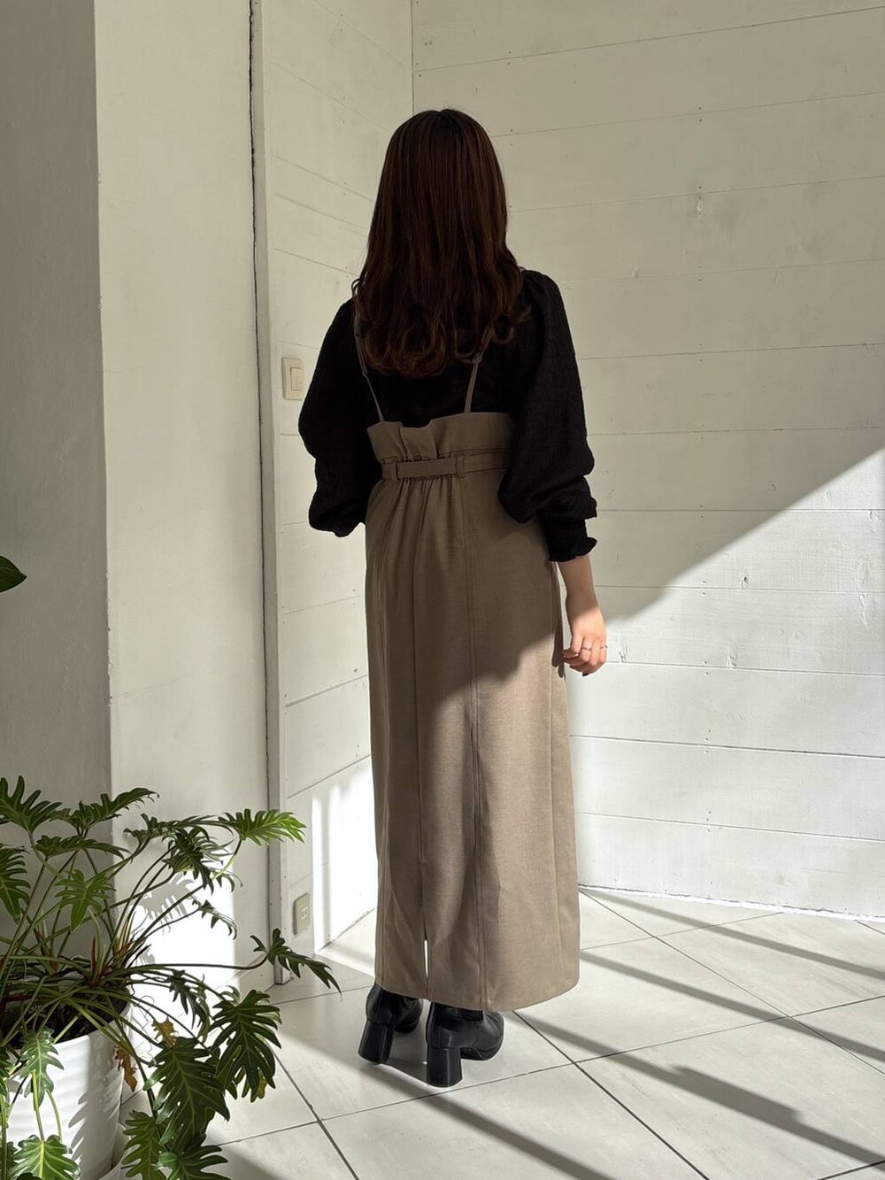 ブラック系のブーツ、ブラウン系のスカート、ブラック系のシャツ/ブラウスを着用したレディースの冬コーディネートの3枚目の写真