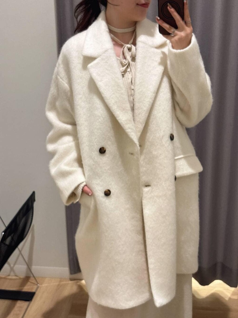 ブラウン系のローファー、ホワイト系のチェスターコート、ホワイト系のワンピースを着用したレディースの秋コーディネートの2枚目の写真