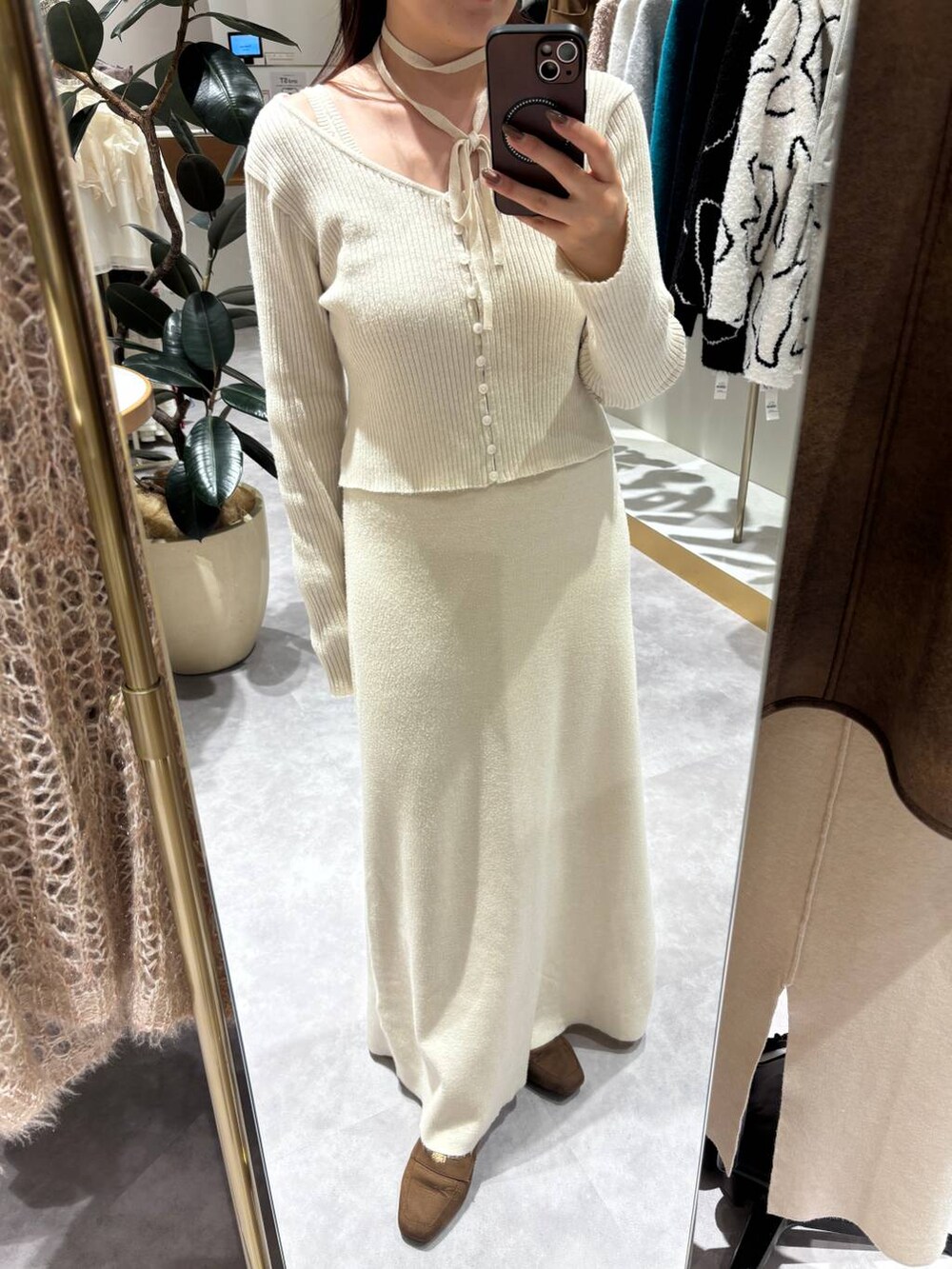 ブラウン系のローファー、ホワイト系のチェスターコート、ホワイト系のワンピースを着用したレディースの秋コーディネートの4枚目の写真