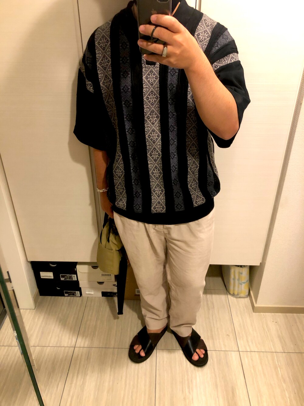 ブラック系のポロシャツ、ベージュ系のその他パンツ、ブラウン系のサンダルを着用したメンズの夏コーディネートの2枚目の写真