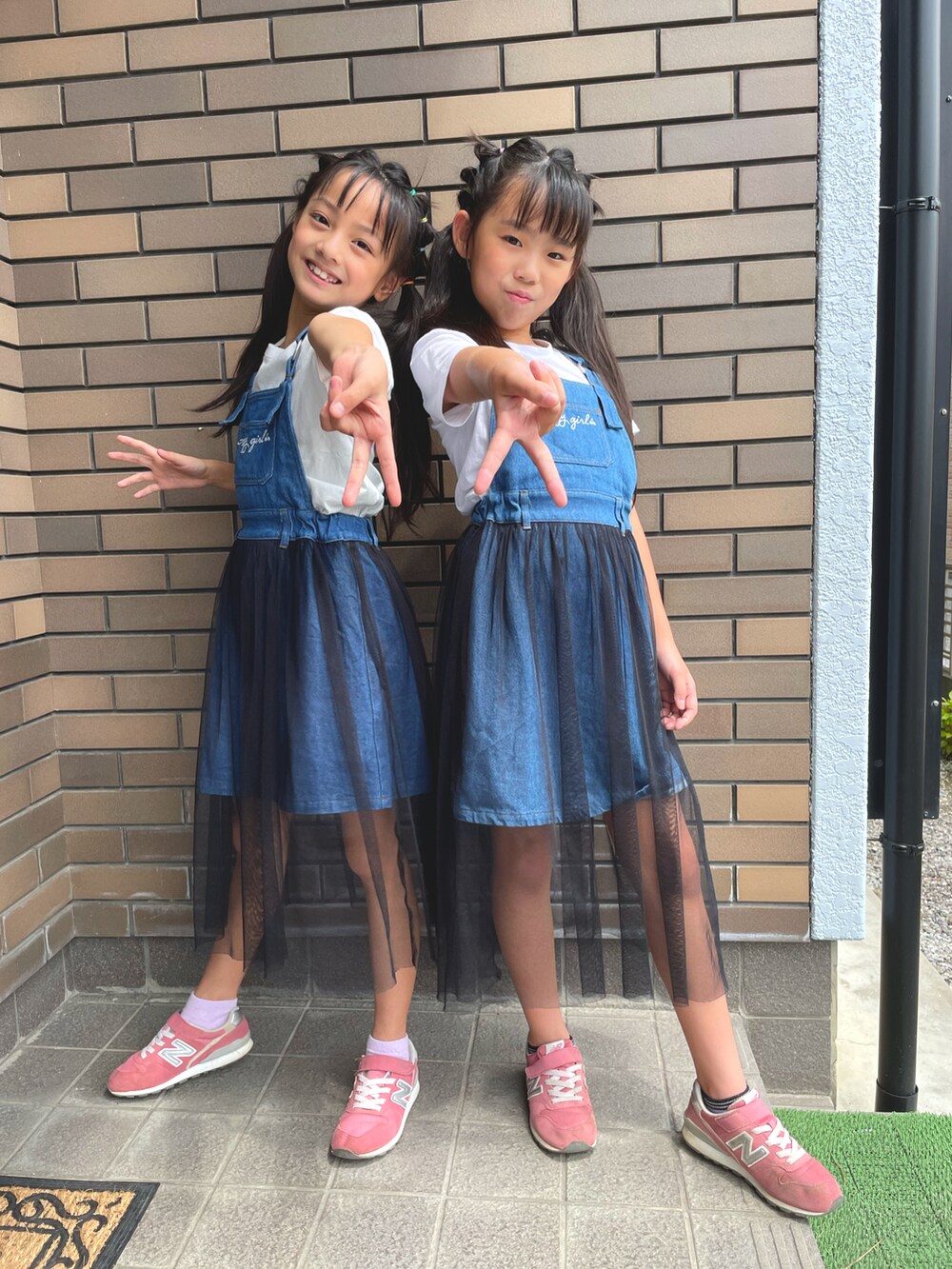 ホワイト系のトップス、ホワイト系のワンピース、ピンク系のスニーカーを着用したキッズの夏コーディネートの4枚目の写真