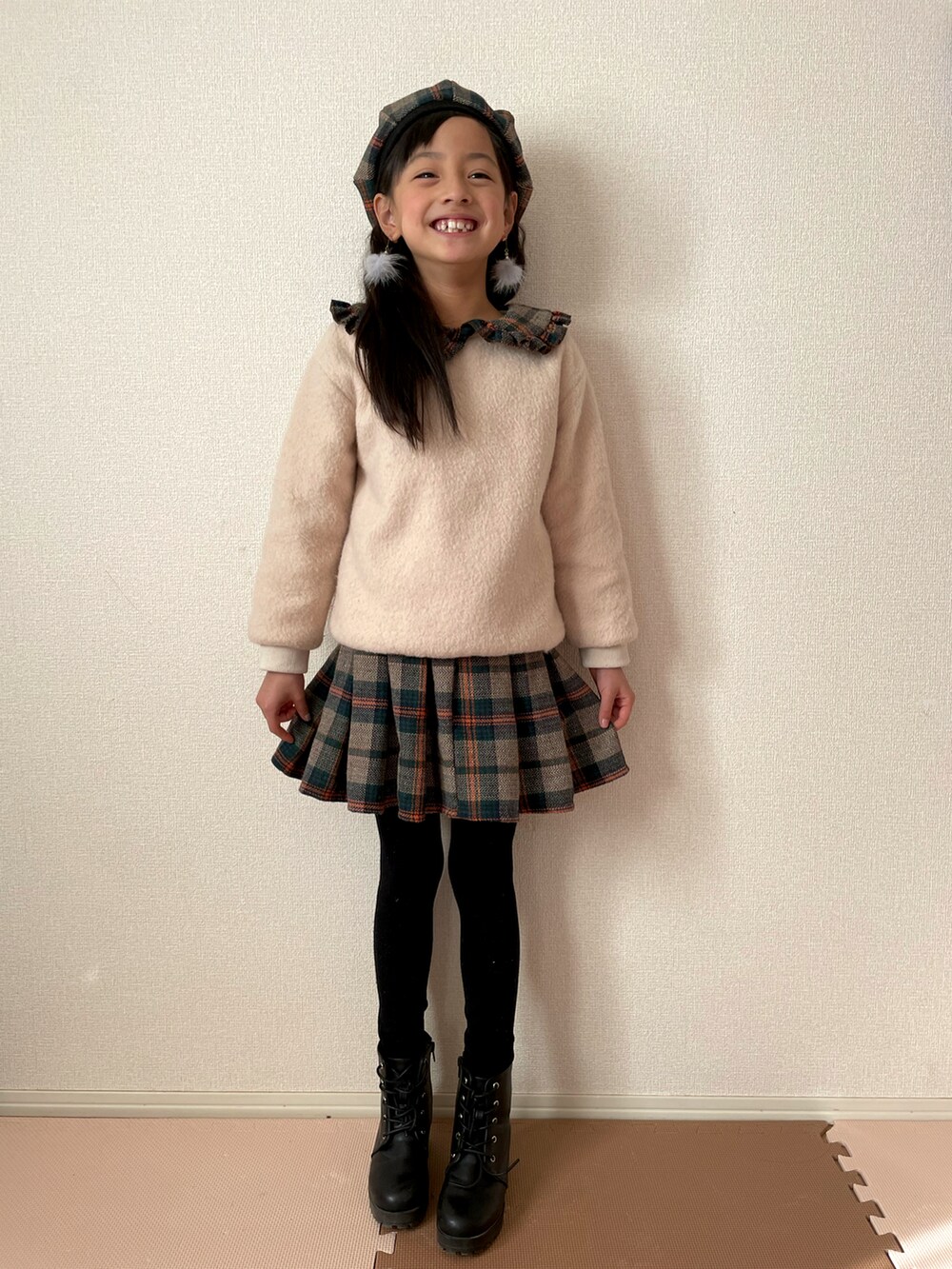 ホワイト系のニット/セーター、ブラック系のブーツを着用したキッズの冬コーディネートの2枚目の写真