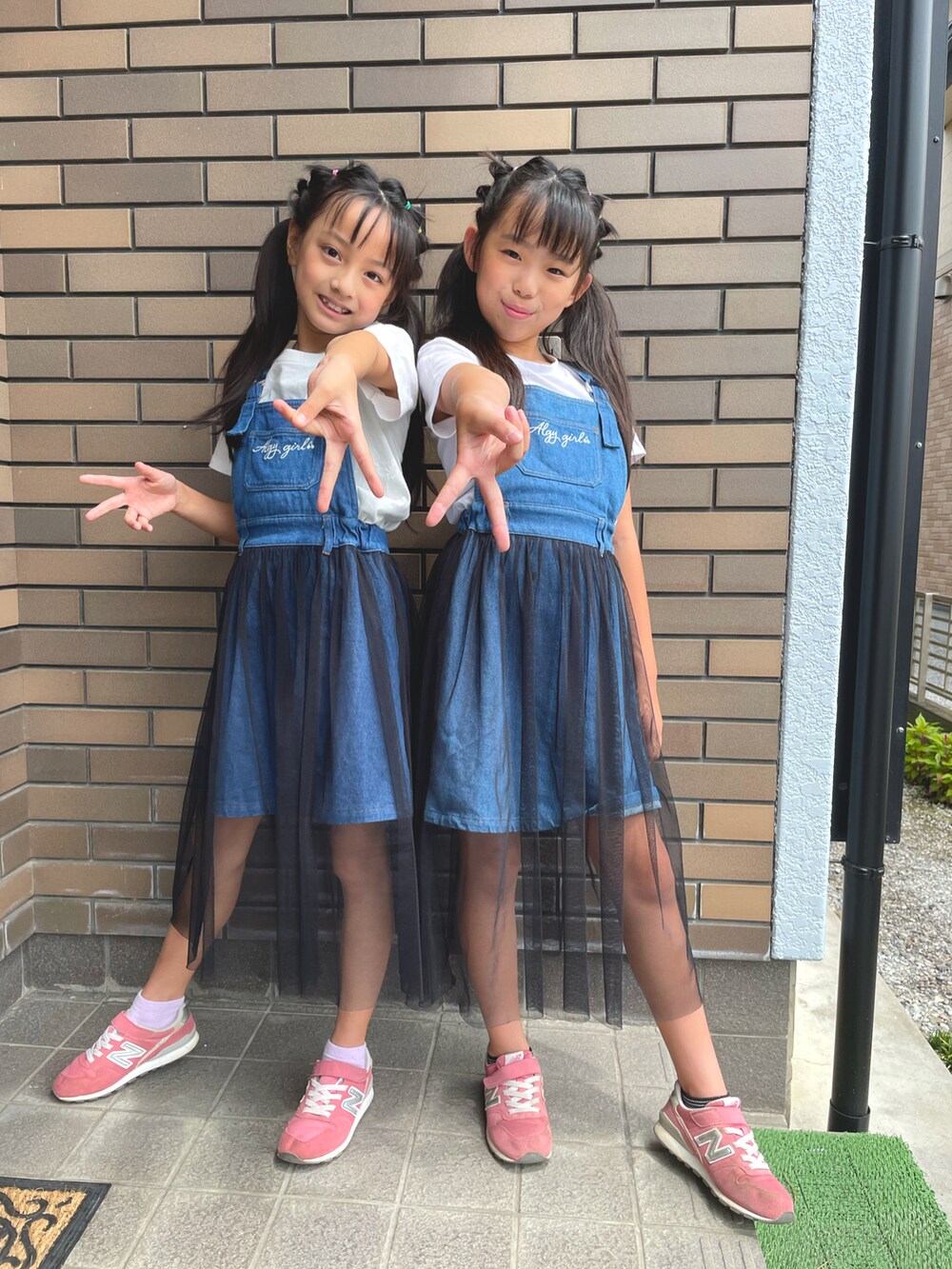 ホワイト系のトップス、ホワイト系のワンピース、ピンク系のスニーカーを着用したキッズの夏コーディネートの3枚目の写真