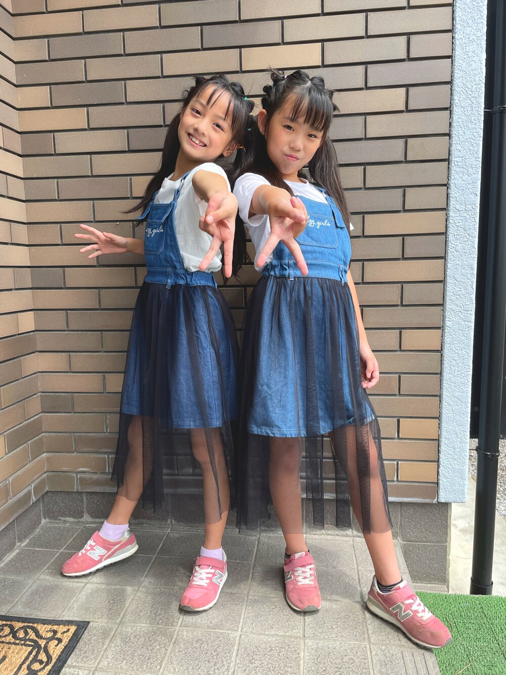 ホワイト系のトップス、ホワイト系のワンピース、ピンク系のスニーカーを着用したキッズの夏コーディネートの2枚目の写真