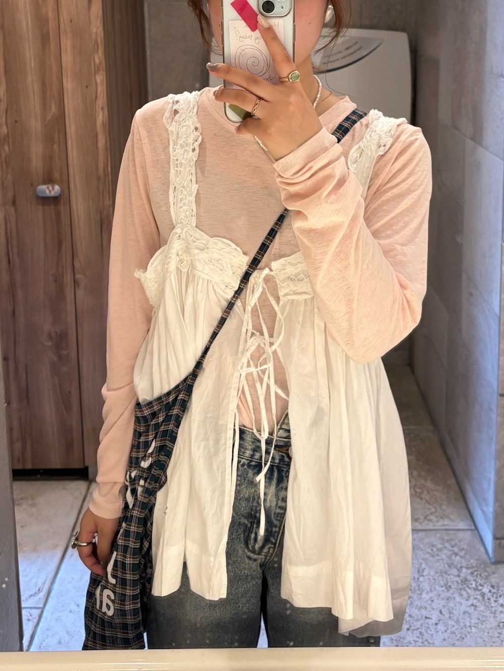 ホワイト系のベスト、ピンク系のTシャツ/カットソー、ブラウン系のバッグを着用したレディースの秋コーディネートの2枚目の写真