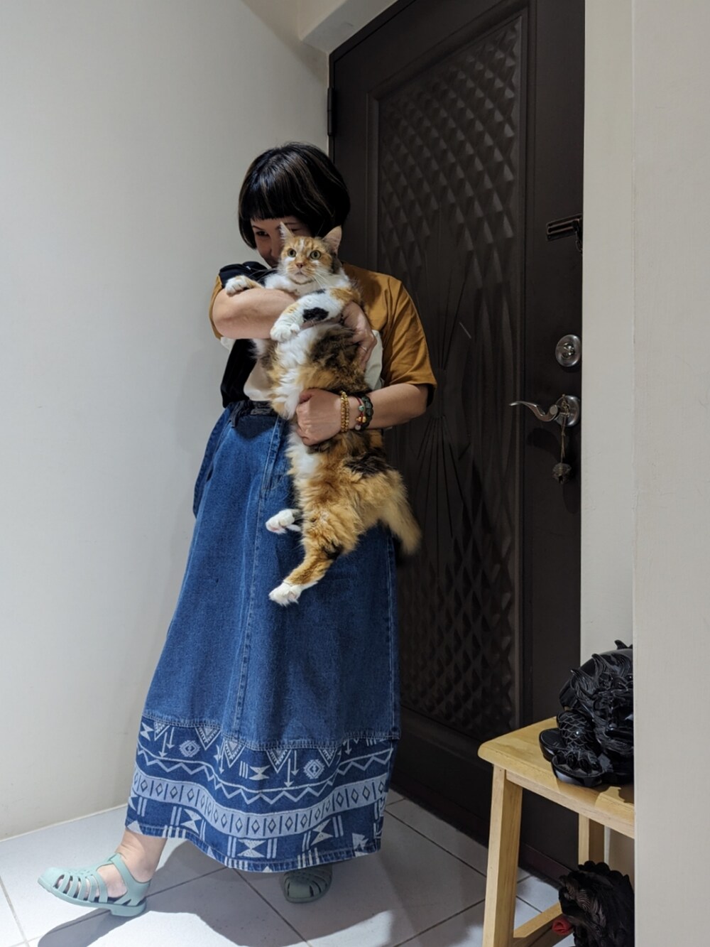 ブラウン系のTシャツ/カットソー、ブルー系のデニムスカートを着用したレディースの秋コーディネートの2枚目の写真