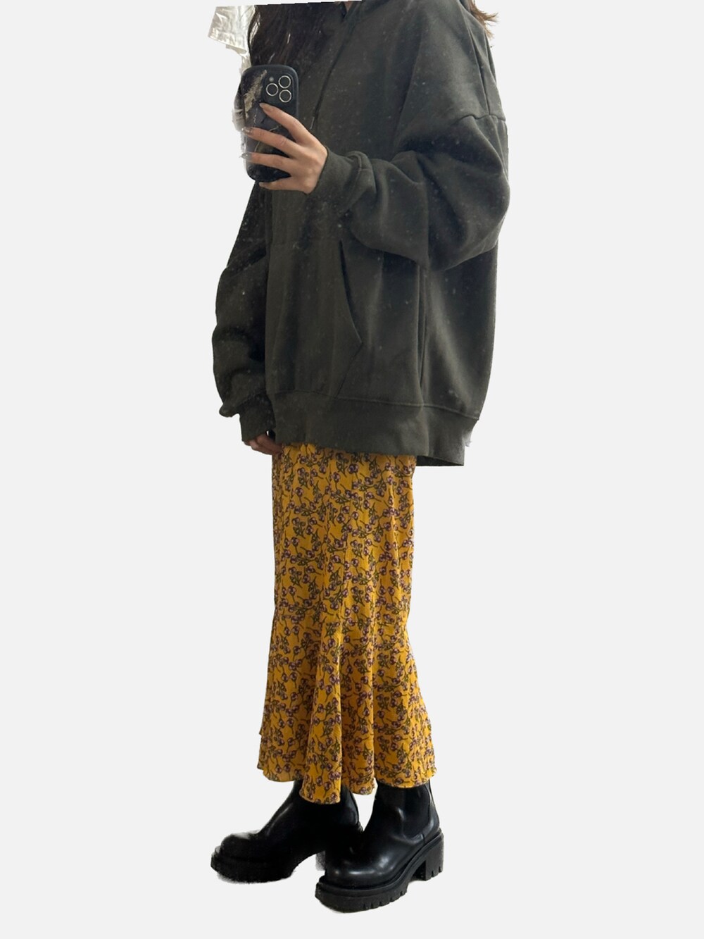 グリーン系のパーカー、ゴールド系のスカート、ブラック系のブーツを着用したレディースの冬コーディネートの2枚目の写真