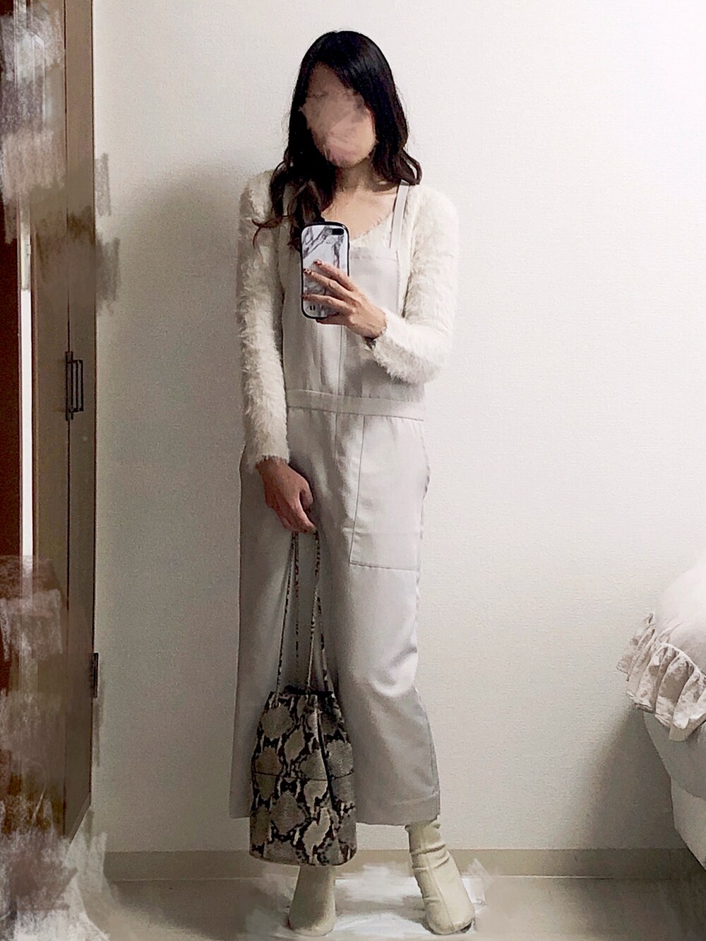 ベージュ系のジャンパースカート、ベージュ系のチェスターコート、その他のハンドバッグを着用したレディースの冬コーディネートの2枚目の写真