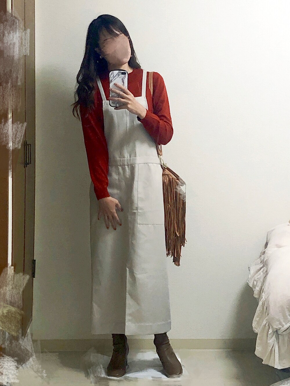 ベージュ系のジャンパースカート、レッド系のニット/セーター、ブラウン系のショルダーバッグを着用したレディースの秋コーディネートの2枚目の写真