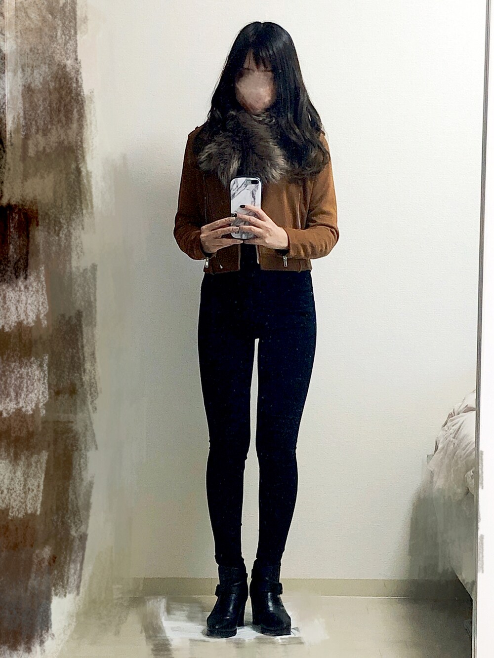 ブラック系のデニムパンツ、ブラック系のブーツ、ブラック系のハンドバッグを着用したレディースの冬コーディネートの2枚目の写真