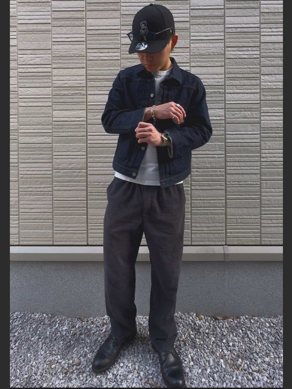 ブルー系のデニムジャケット、ブラック系のブーツ、ブラック系のキャップを着用したメンズの春コーディネートの2枚目の写真