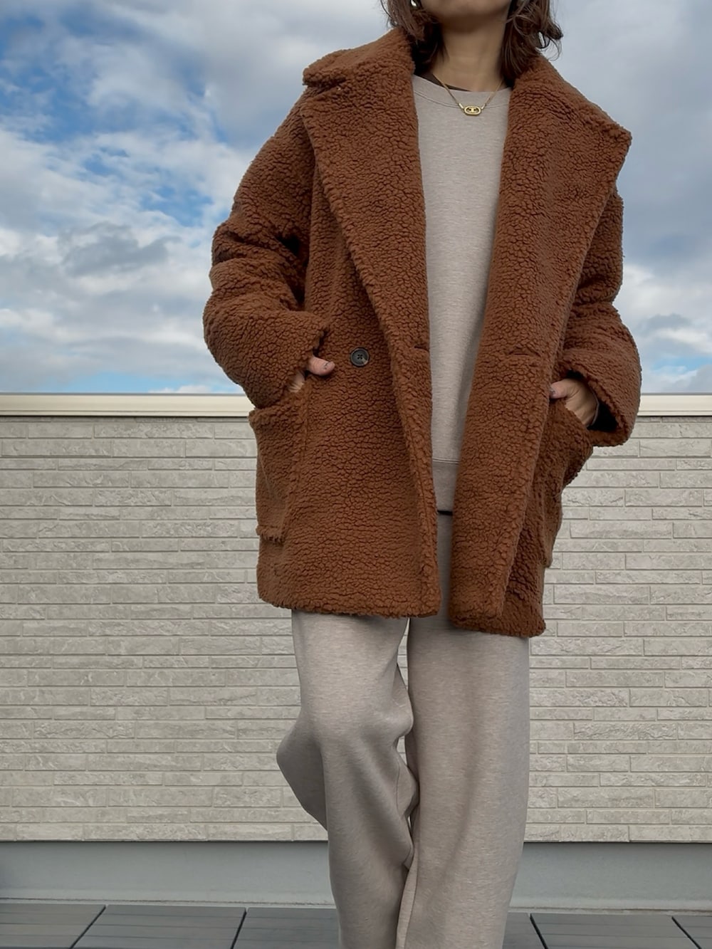 イエロー系のチェスターコートを着用したレディースの冬コーディネートの3枚目の写真