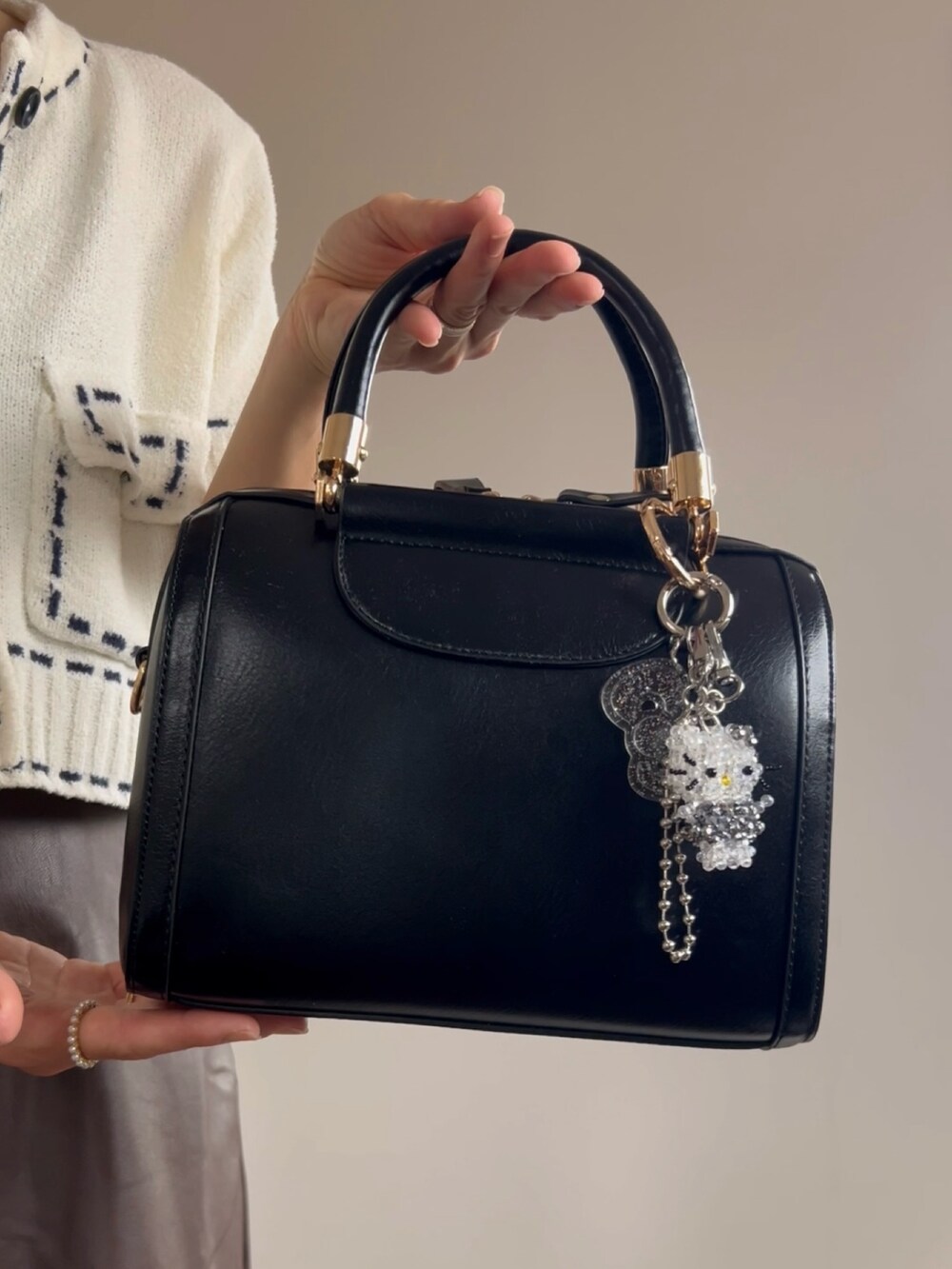 ブラック系のボストンバッグ、ブラウン系のスカートを着用したレディースの夏コーディネートの4枚目の写真