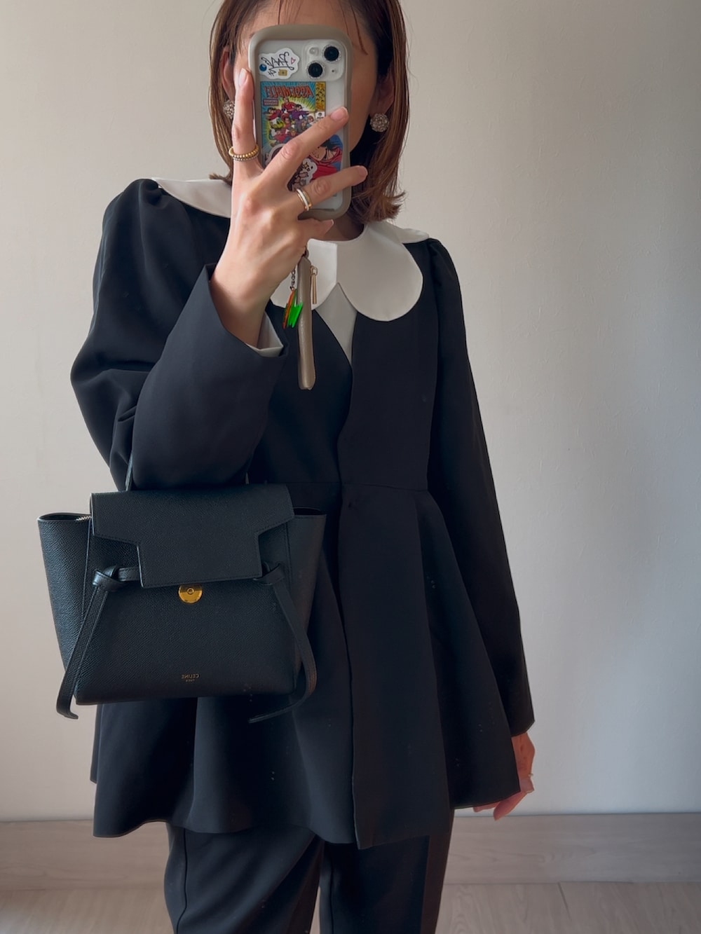 ブラック系のスーツセット、ブラック系のパンプスを着用したレディースの冬コーディネートの5枚目の写真