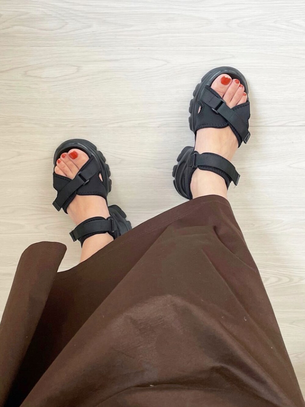 ブラック系のサンダルを着用したレディースの春コーディネートの2枚目の写真