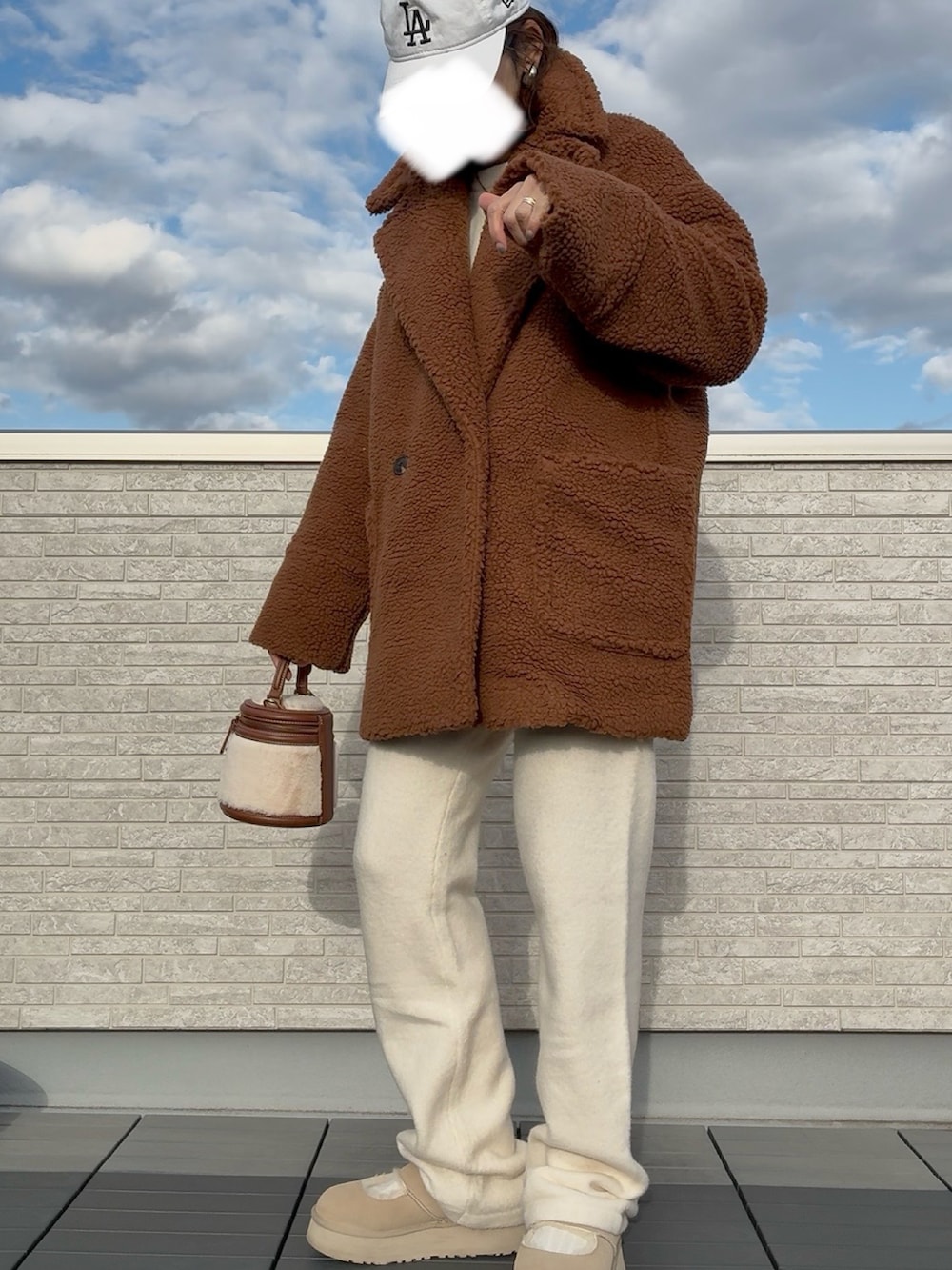 イエロー系のチェスターコートを着用したレディースの冬コーディネートの2枚目の写真