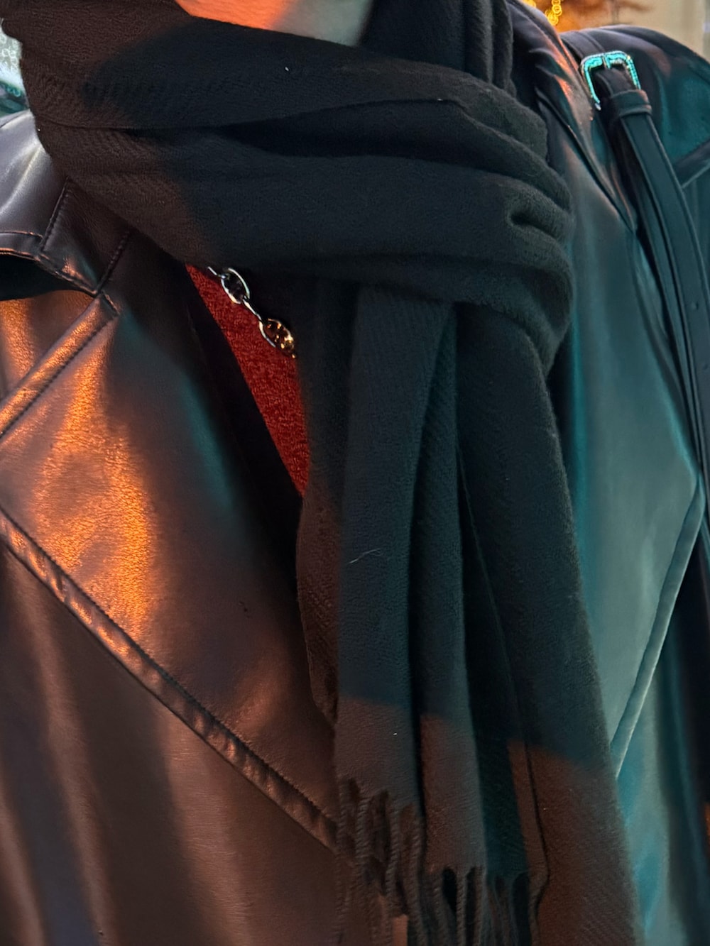 ブラック系のトレンチコート、ブラック系のデニムパンツ、レッド系のニット/セーターを着用したメンズの冬コーディネートの2枚目の写真