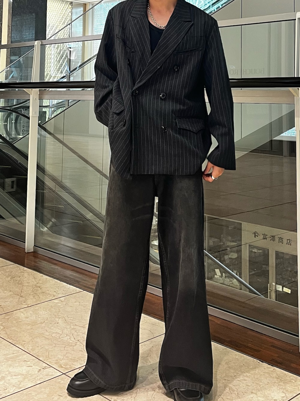 ブラック系のデニムパンツ、グレー系のテーラードジャケット、ブラック系のローファーを着用したメンズの秋コーディネートの2枚目の写真