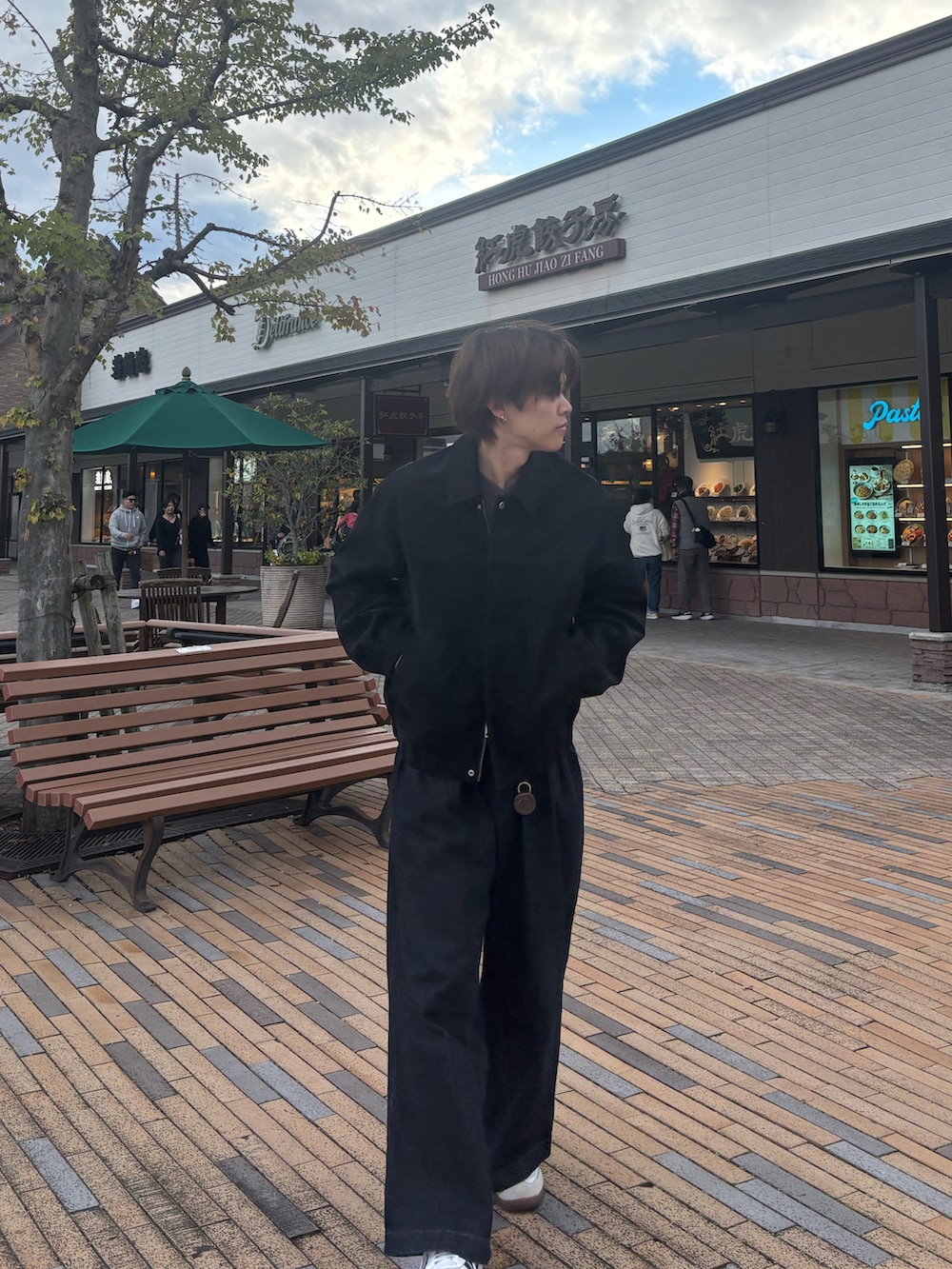 ブラウン系のニット/セーター、ブルー系のデニムパンツ、ホワイト系のスニーカーを着用したメンズの秋コーディネートの2枚目の写真