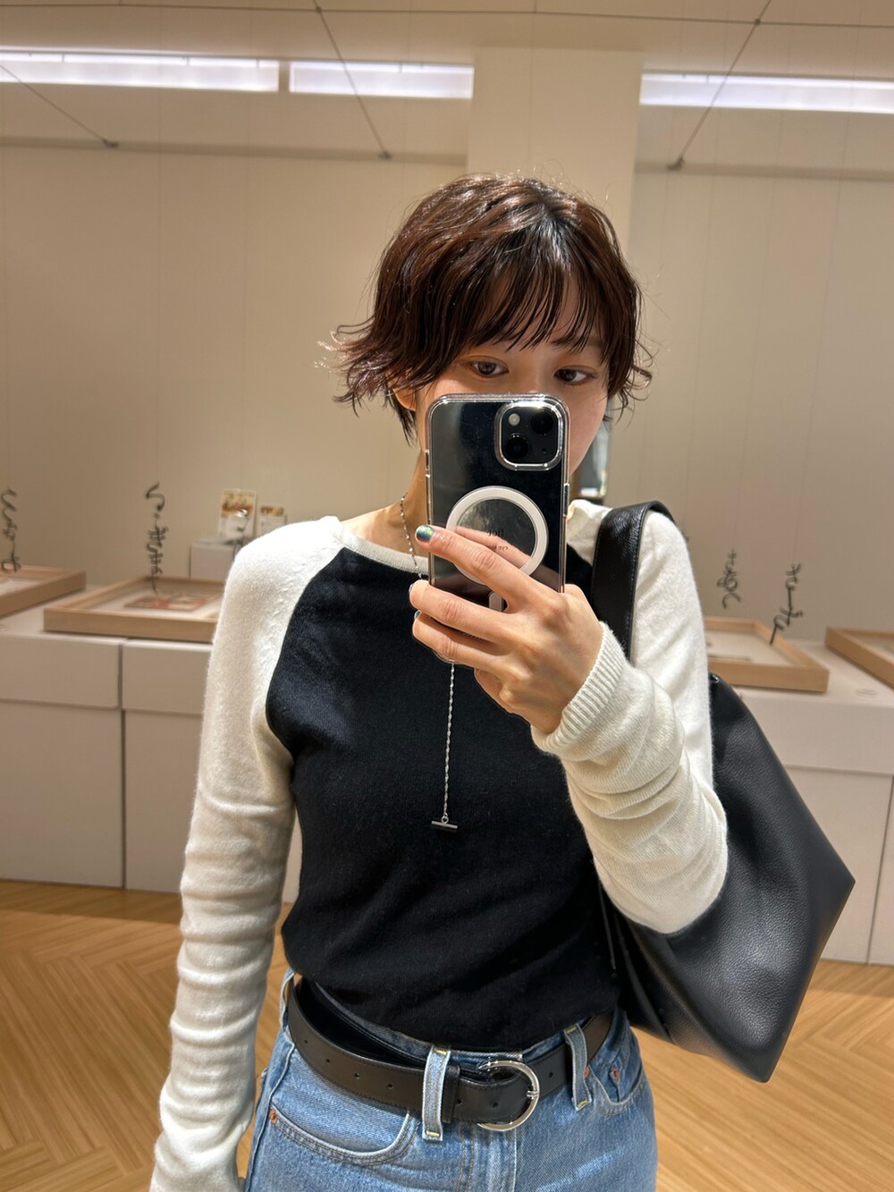 ブルー系のデニムパンツ、ブラック系のローファー、ブラック系のニット/セーターを着用したレディースの冬コーディネートの2枚目の写真